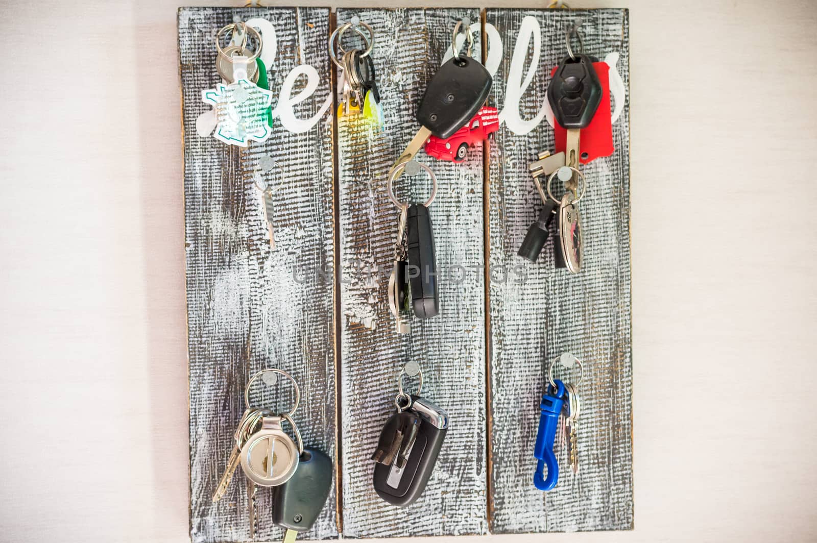 cars keys with tags hanging on a wooden board in the background