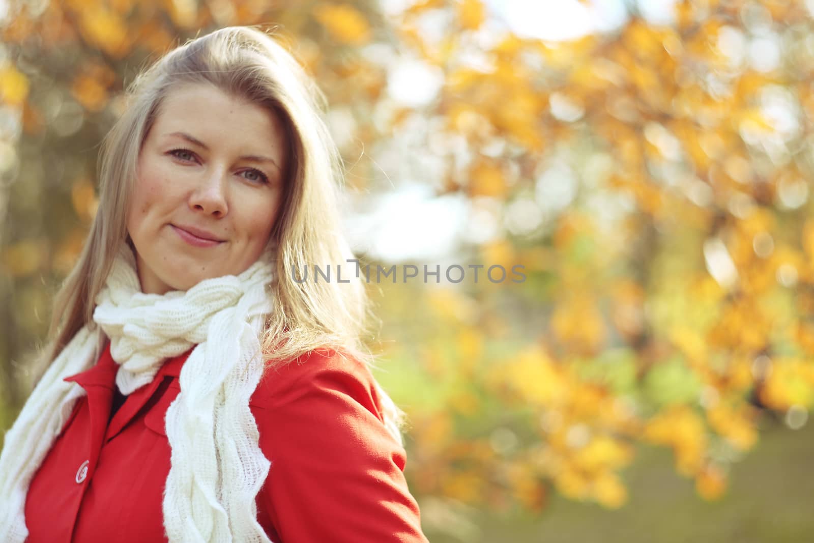Young beautiful smiling woman in sunny autumn park