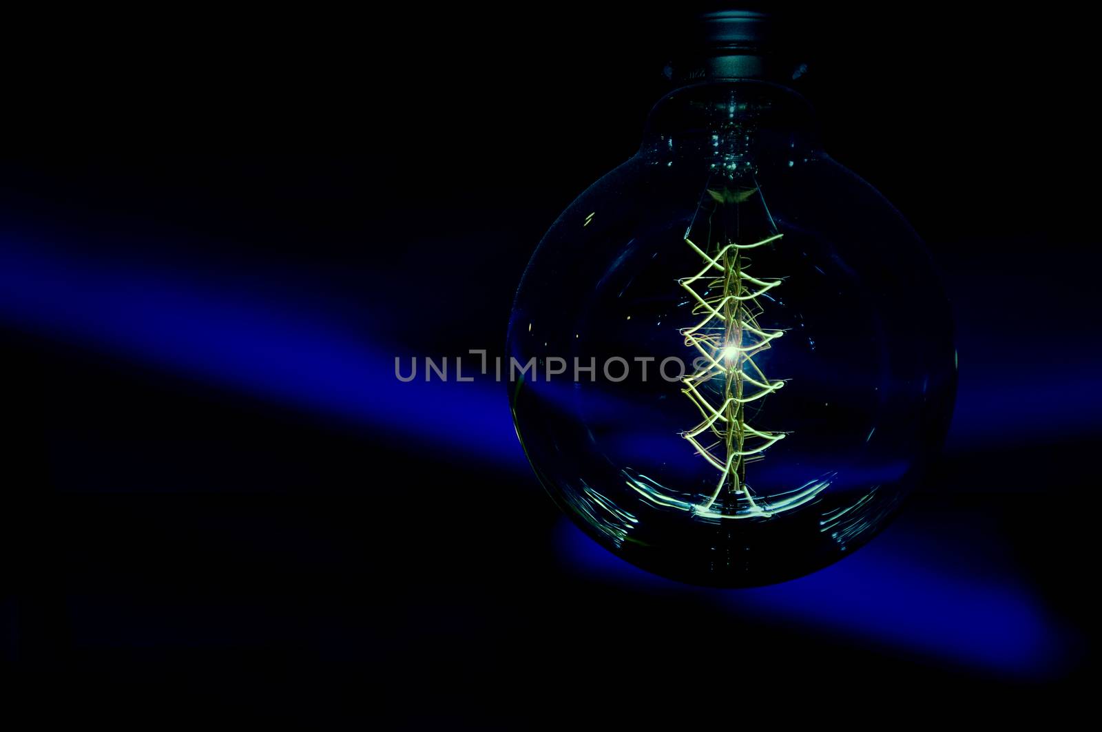 Bright electric light or bulb on a dark background. a photo