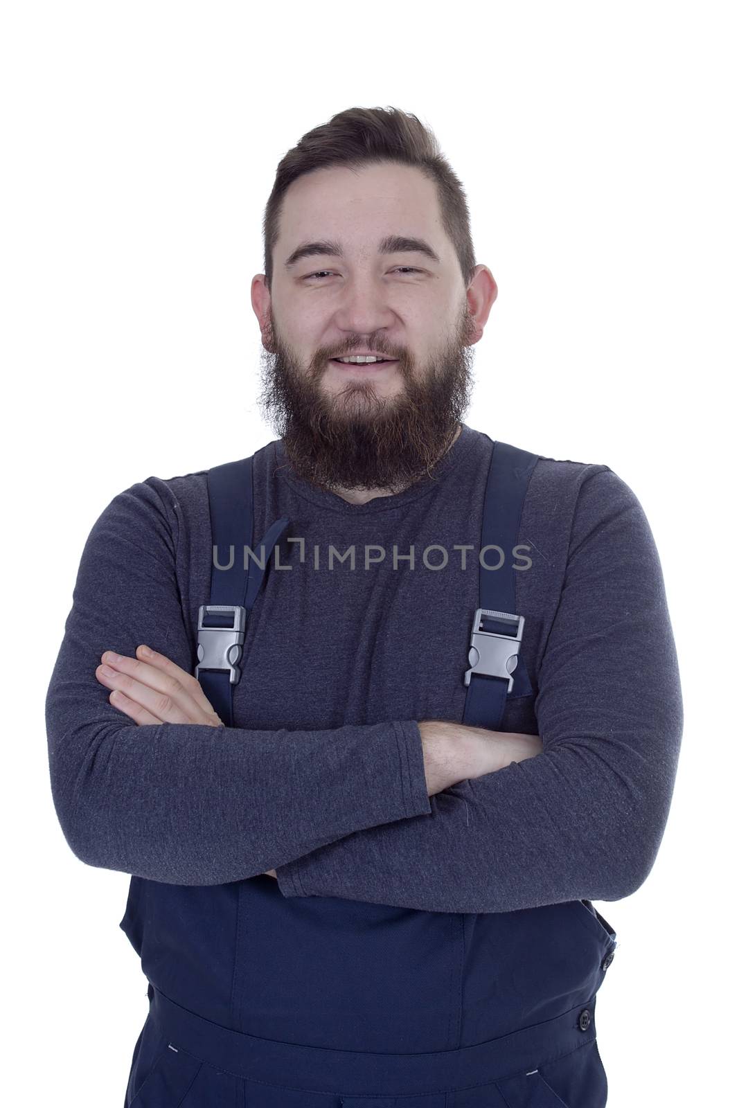 Portrait of happy handyman in overalls standing arms crossed over white backgound
