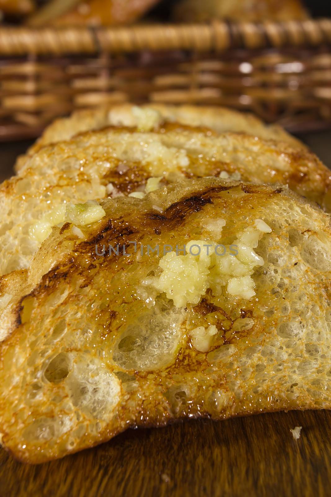 Fried garlic bread and garlic closeup on a wooden board