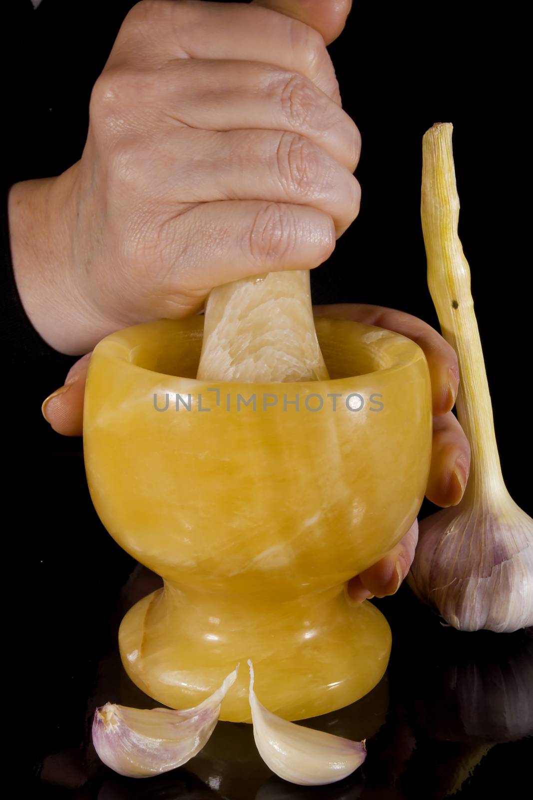 Garlic in mortar and pestle on a black background