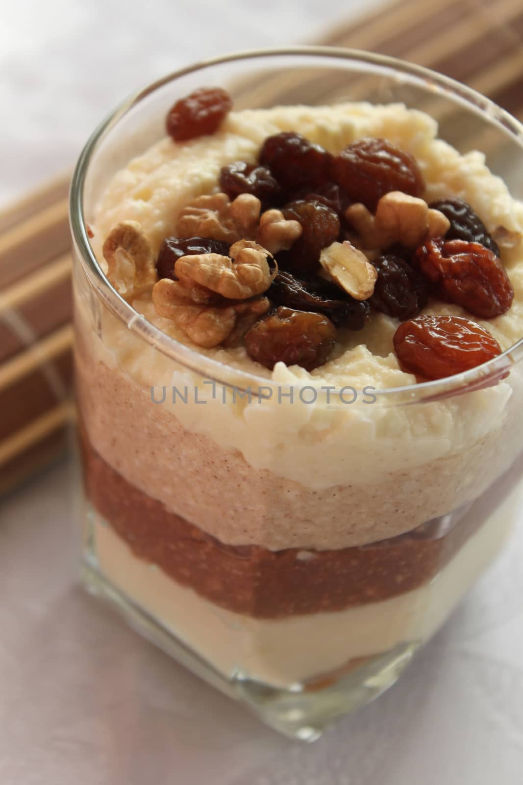 Cheesecake in a glass sprinkled with nuts and raisins by Kasia_Lawrynowicz