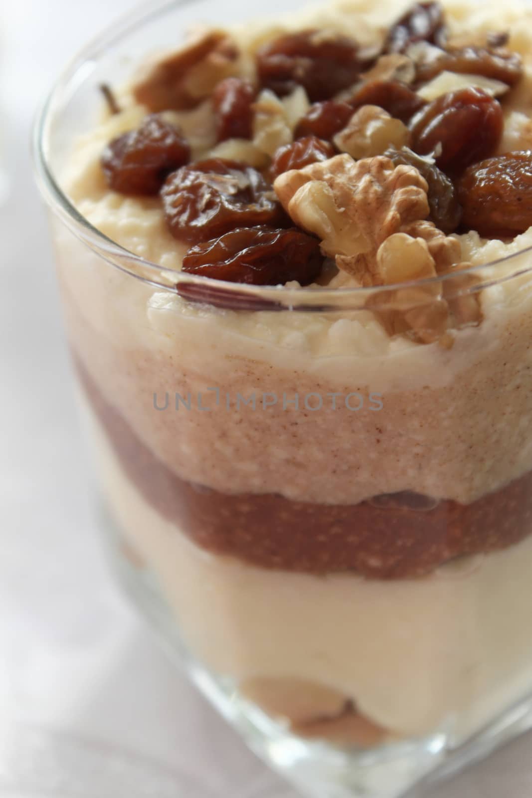 Cheesecake in a glass sprinkled with nuts and raisins by Kasia_Lawrynowicz