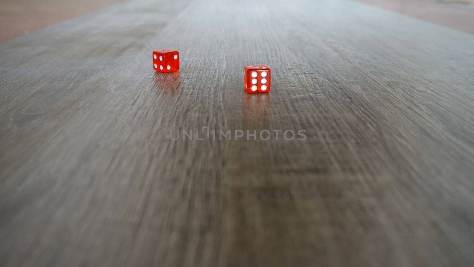 Throwing red dice on a grey background in the casino.