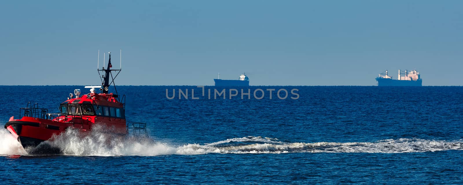 Red pilot ship moving from the Baltic sea