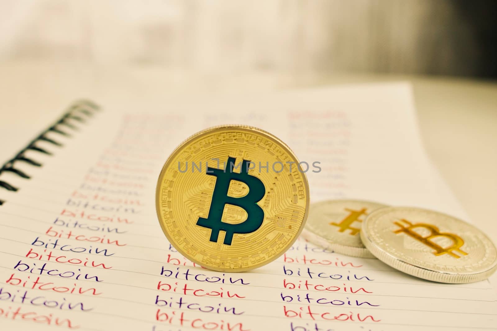 Digital currency physical gold and silver bitcoin coins in notebook.