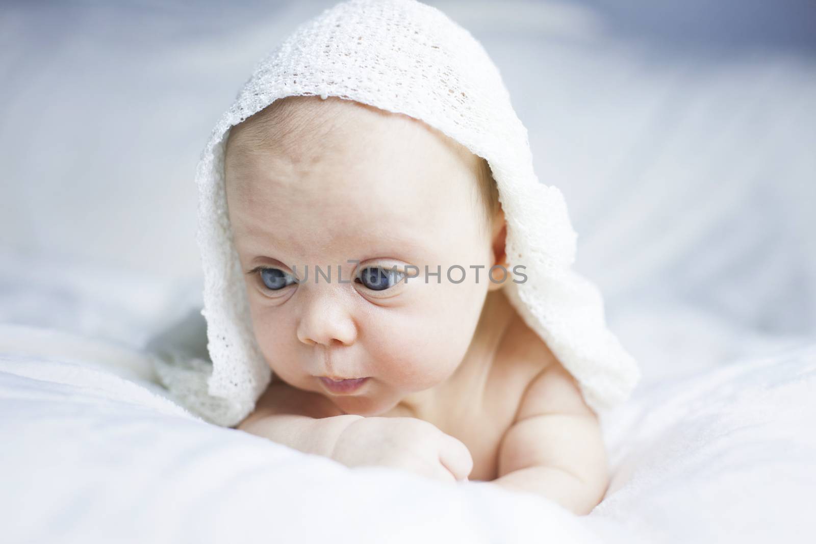 Beautiful baby girl on white blanket. Studio shot