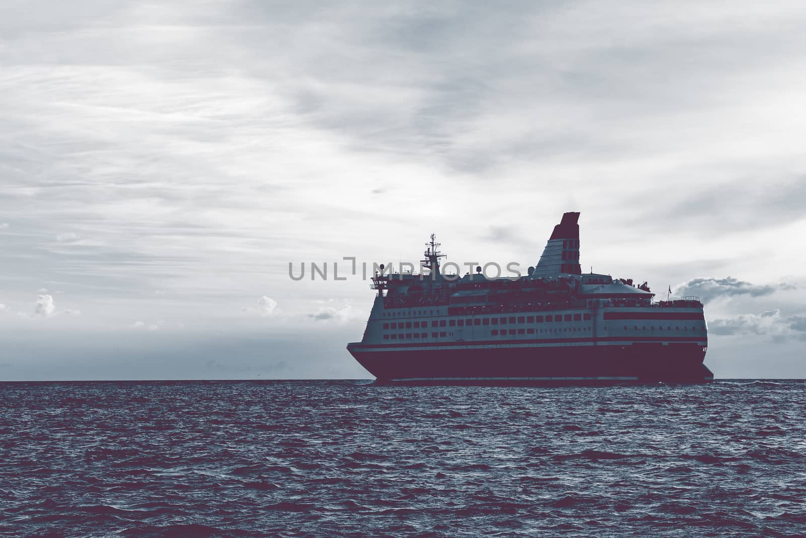 Cruise liner in open sea. Passenger ferry sailing at hot sunset