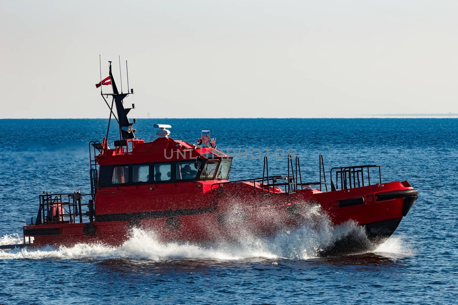 Red pilot ship moving from the Baltic sea