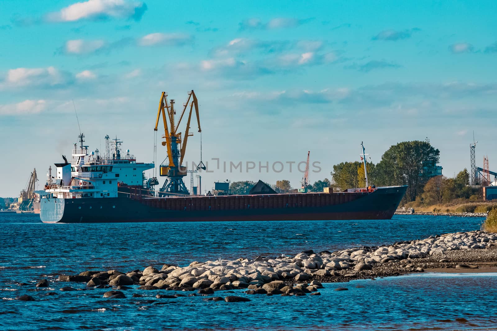 Blue cargo ship moving to the cargo port