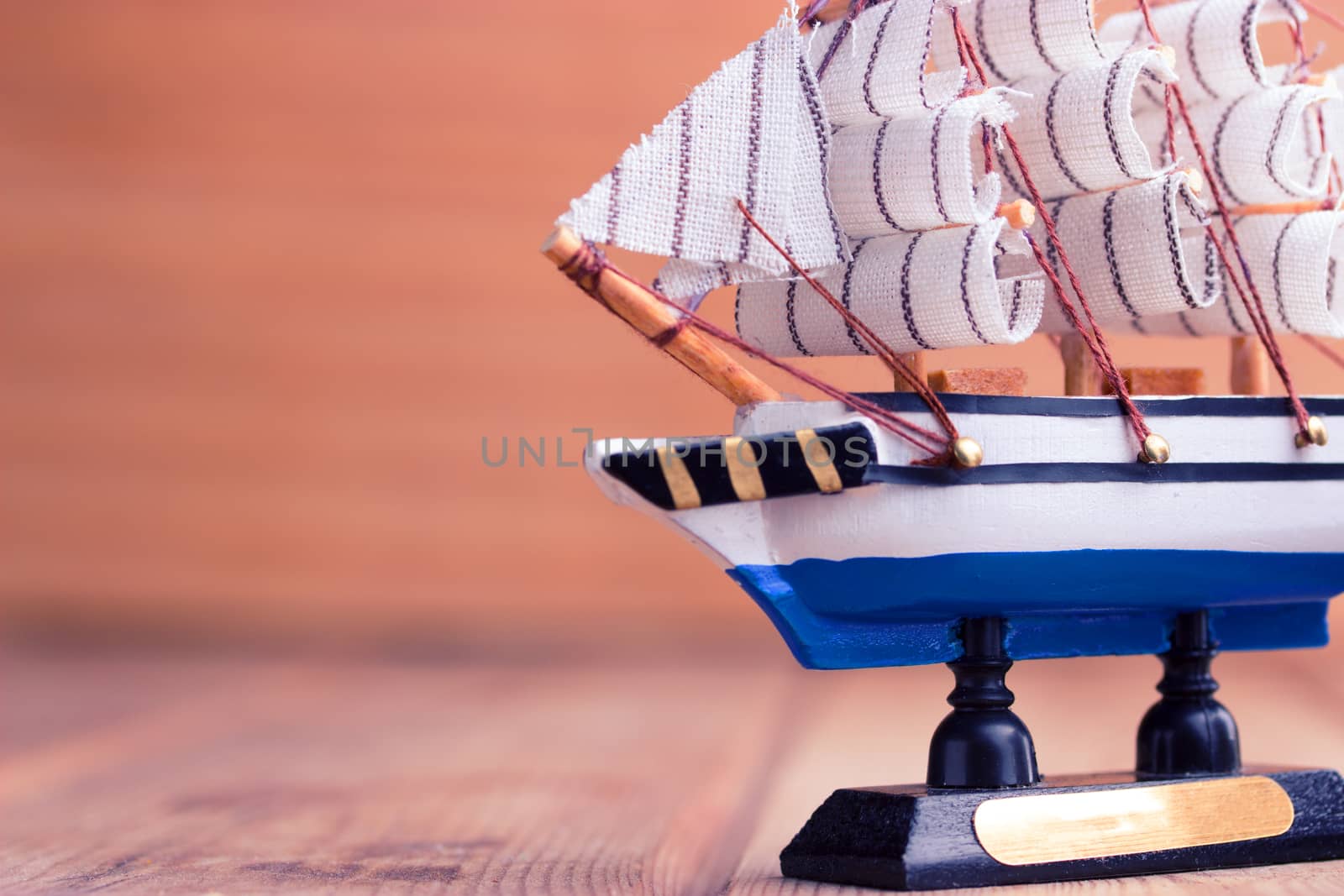 Toy sailboat on a wooden background with copy space