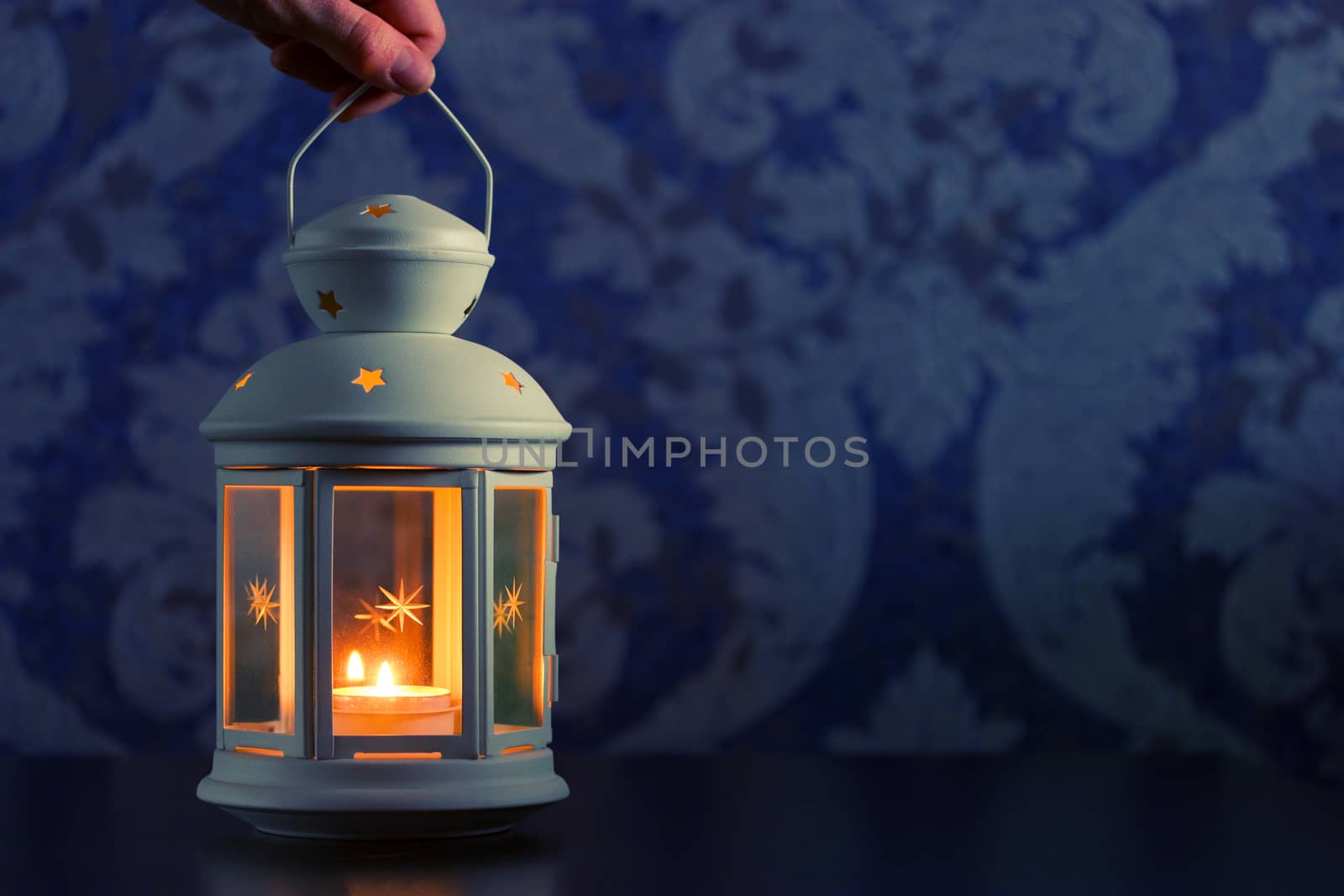 beautiful white lantern in hand. blue background
