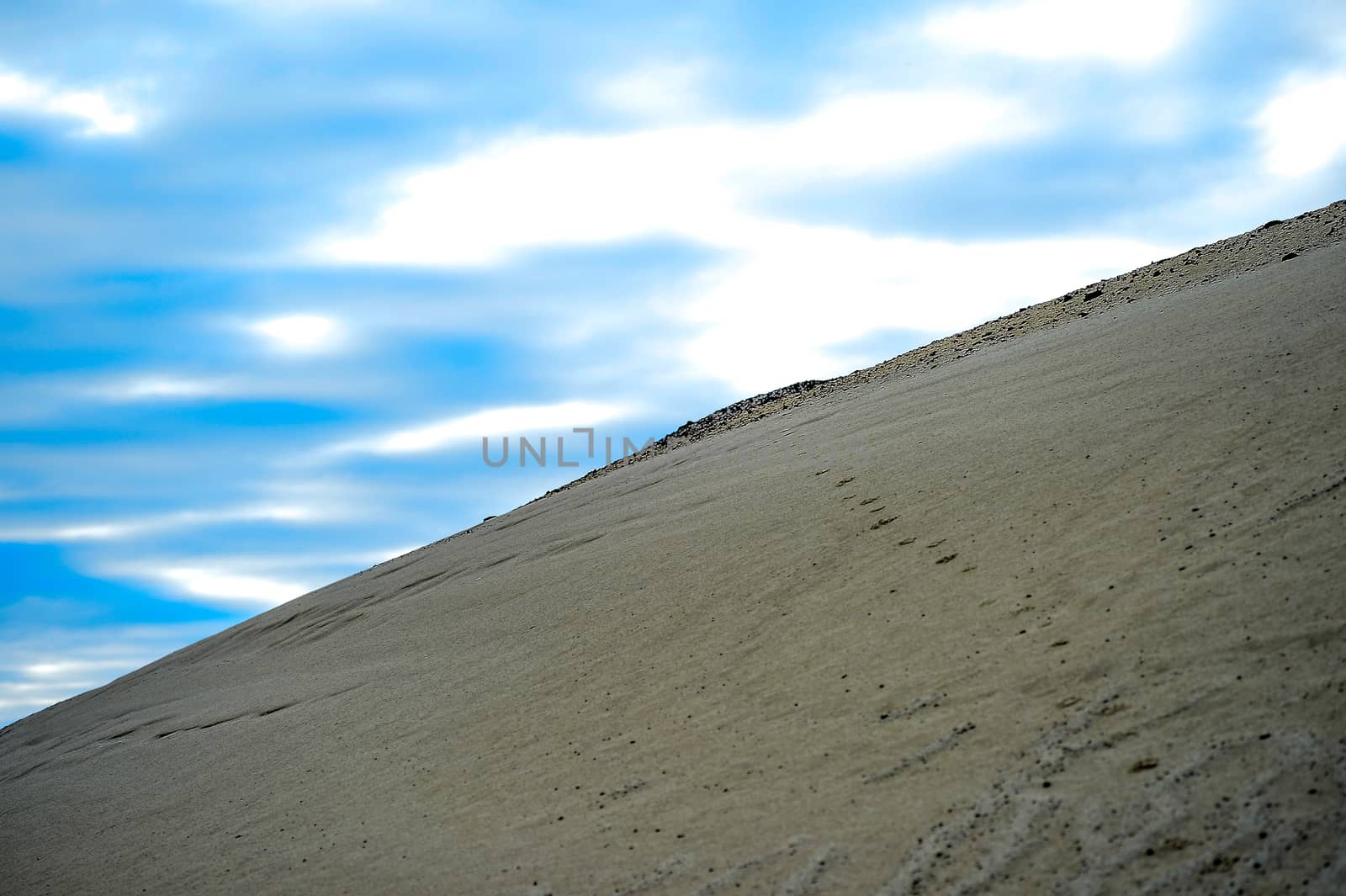 Sandy hill in a quarry against the sky.