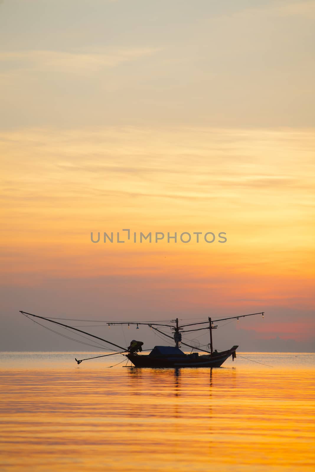 Orange sky with sunset over sea shore and silhouette fishing boat,Hat Pha Daeng Chumphon Thailand.