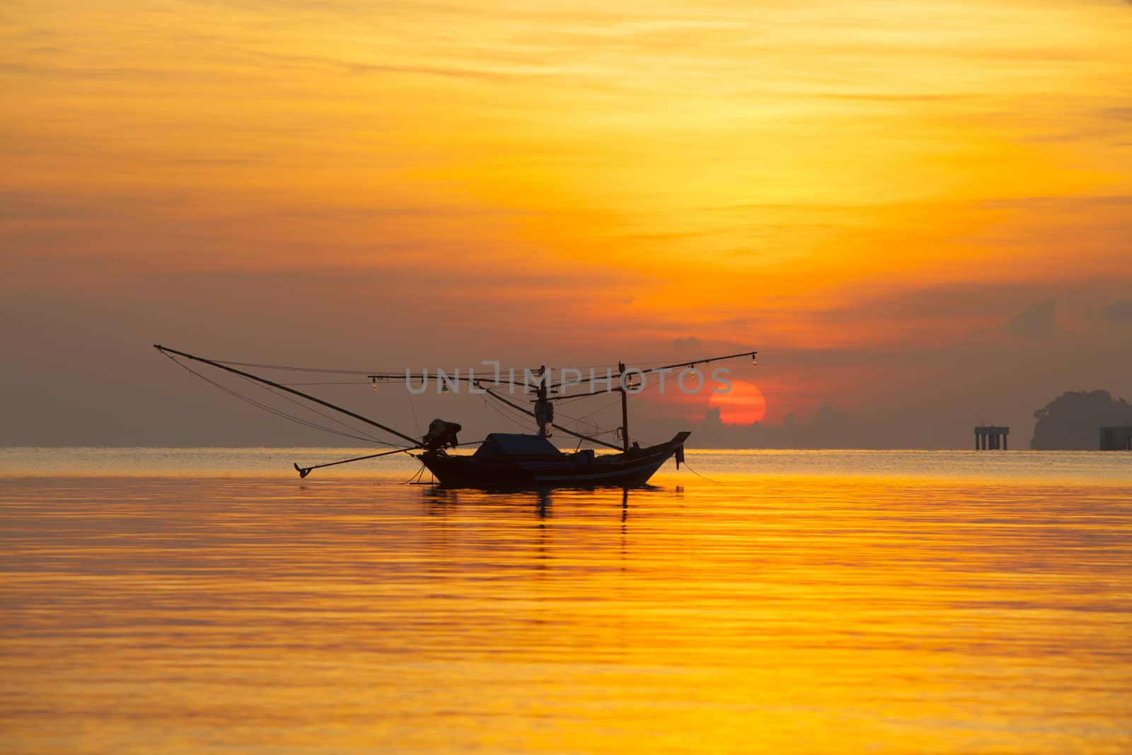 Orange sky with sunset over sea shore and silhouette fishing boat,Hat Pha Daeng Chumphon Thailand.