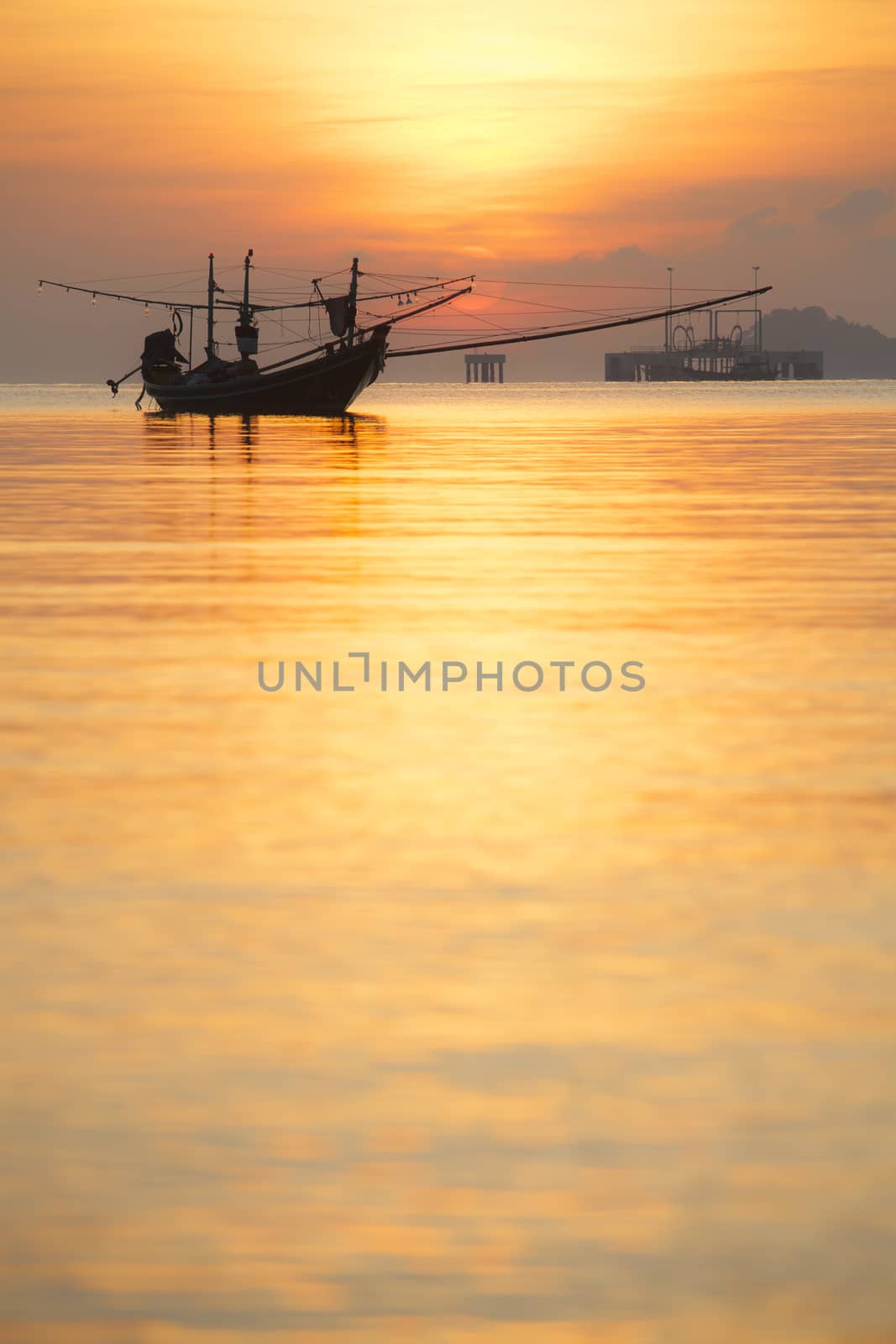 Orange sky with sunset over sea shore and silhouette fishing boat,Hat Pha Daeng Chumphon Thailand.