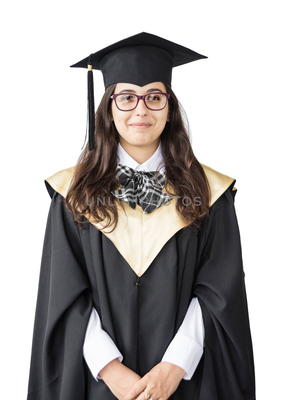 Young girl graduate of the University with glasses, academic cap and black gown, standing isolated on white background