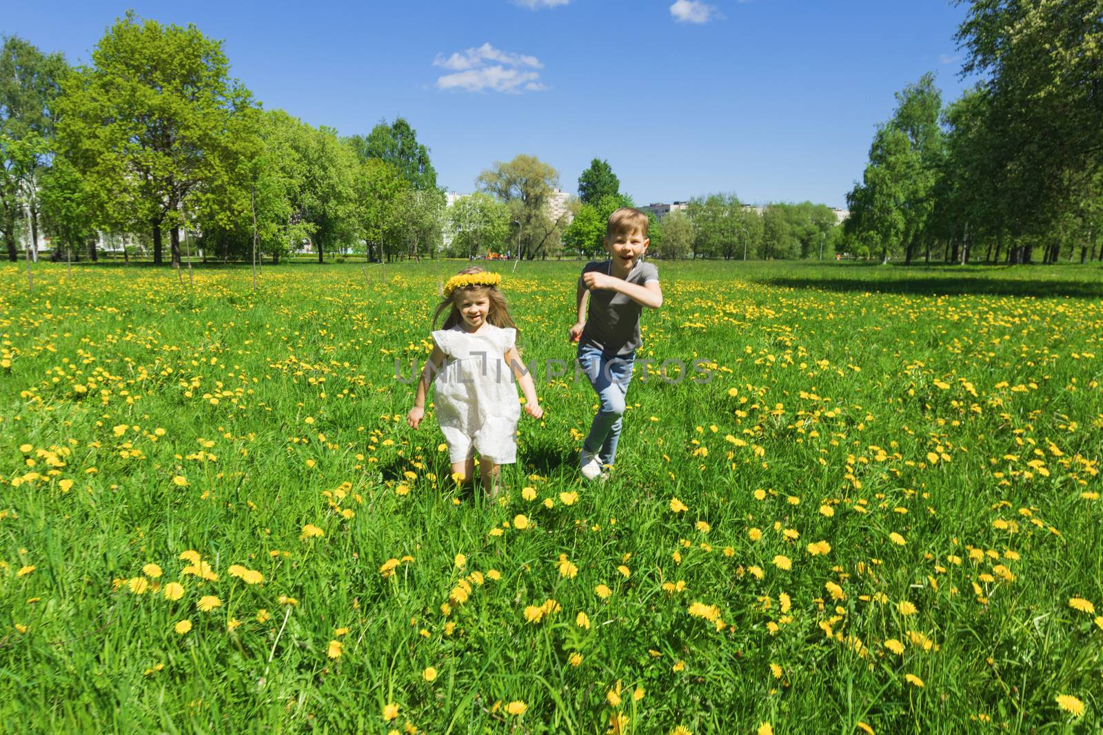 Happy children run on meadow by Yellowj