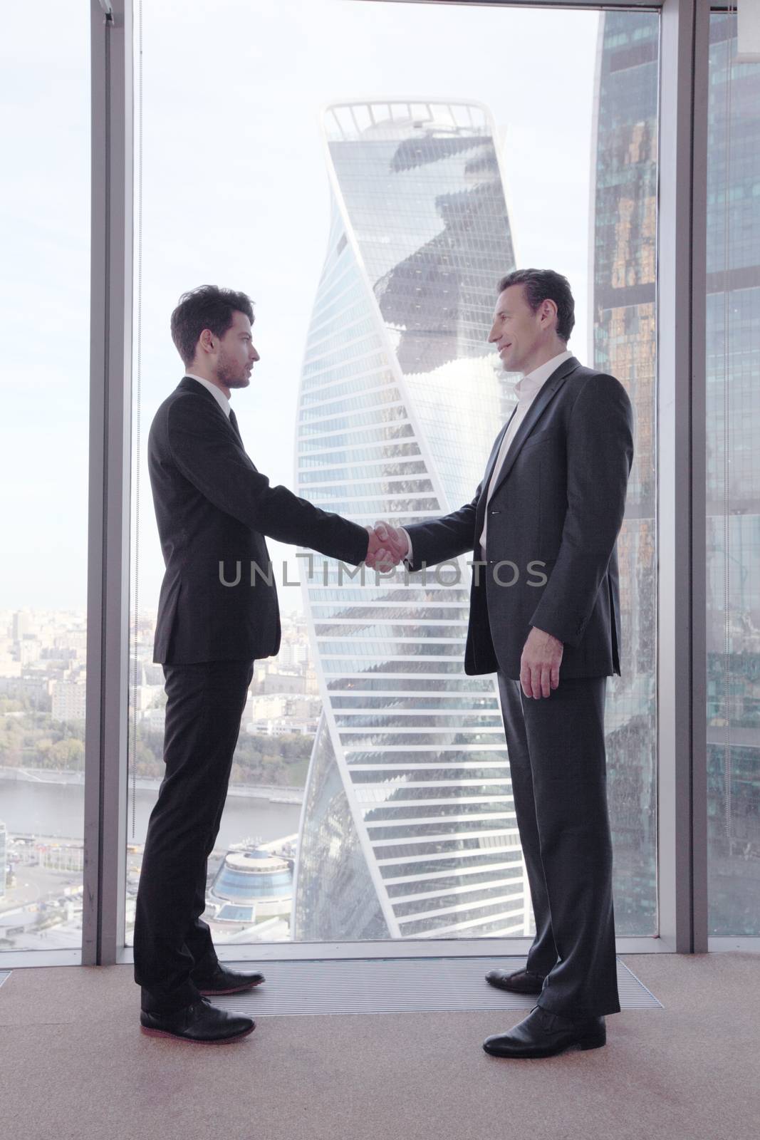 Business people shaking hands by ALotOfPeople