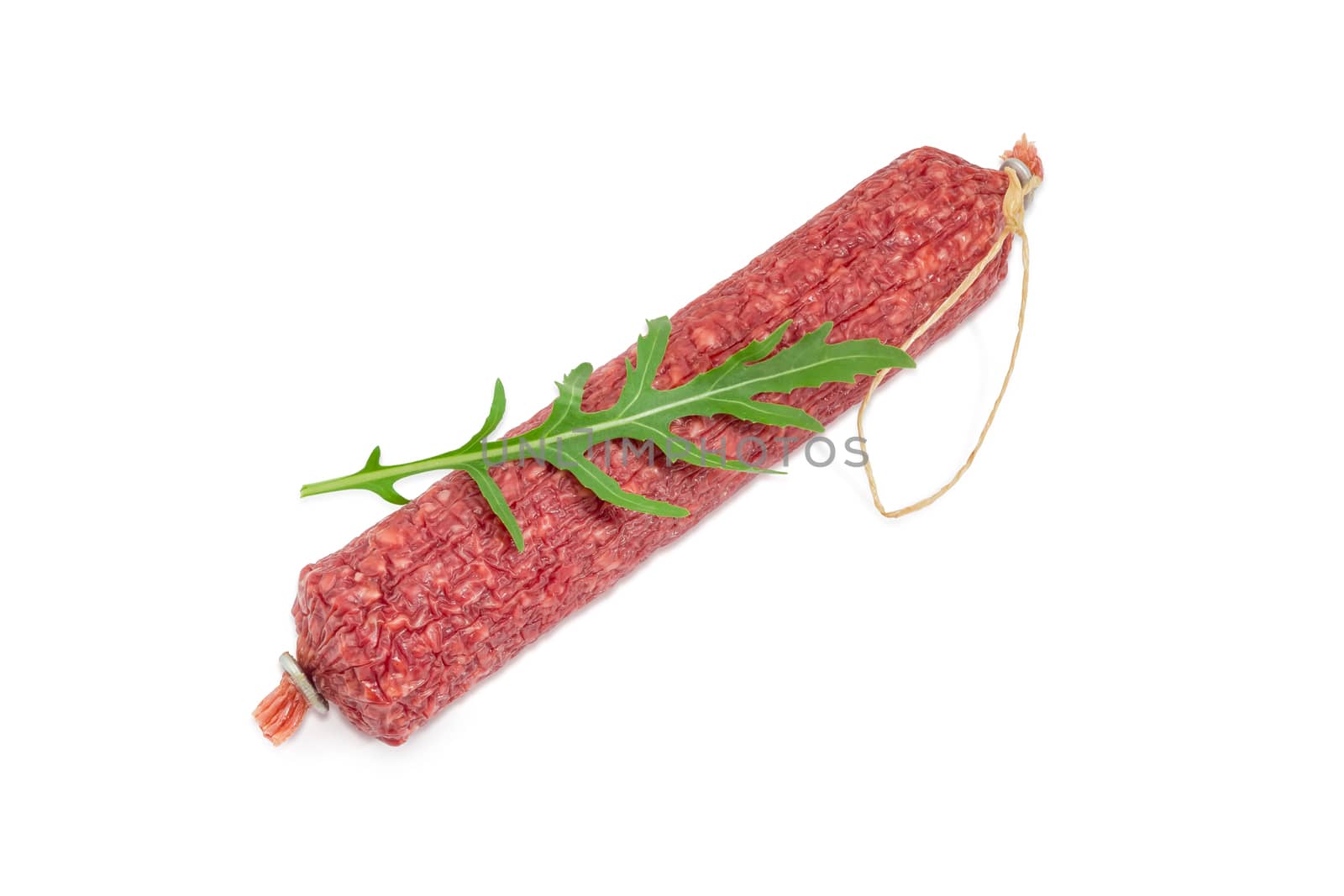 Whole salami and fresh leaf of the arugula on it on a light background
