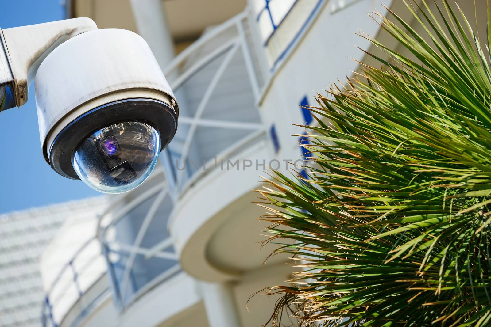security CCTV camera or surveillance system with modern luxury residence on blurry background by pixinoo