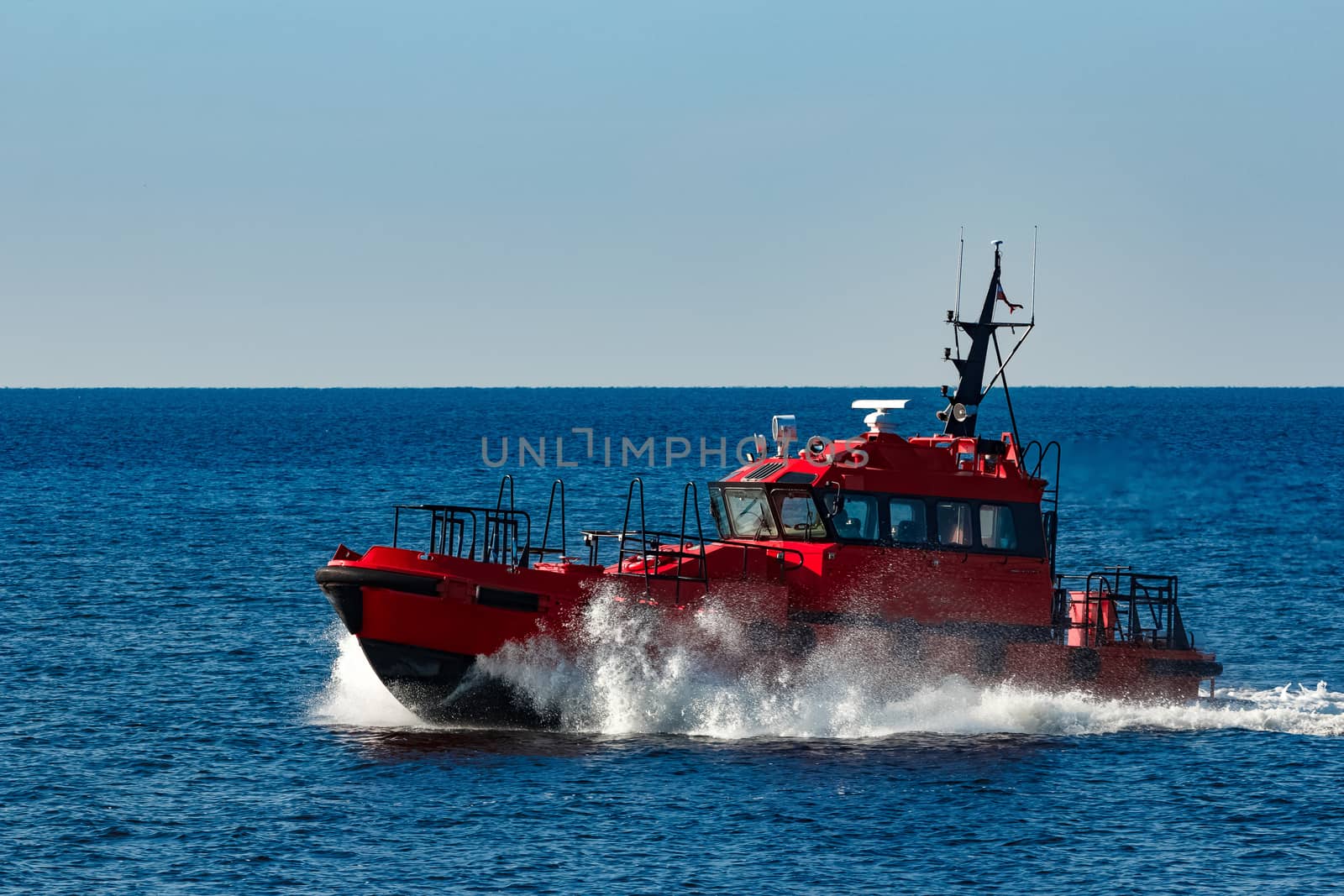 Red pilot ship moving from the Baltic sea