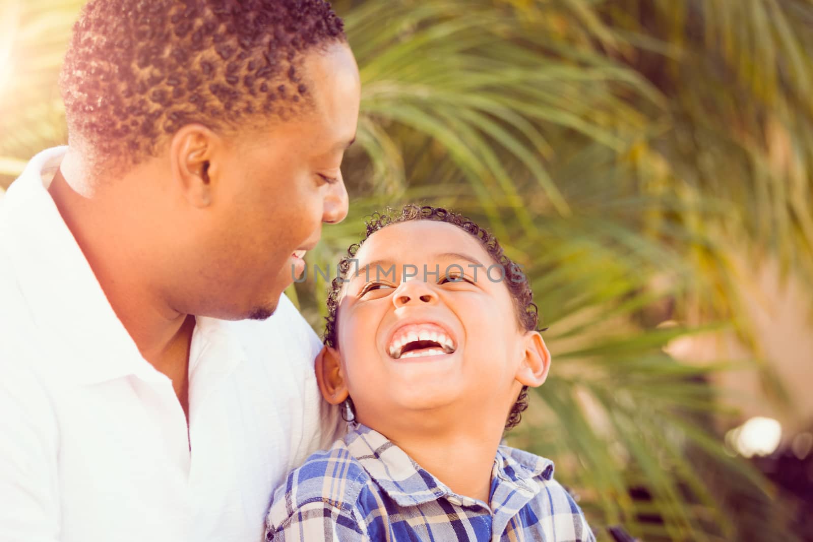 Mixed Race Son and African American Father Playing Outdoors Together. by Feverpitched