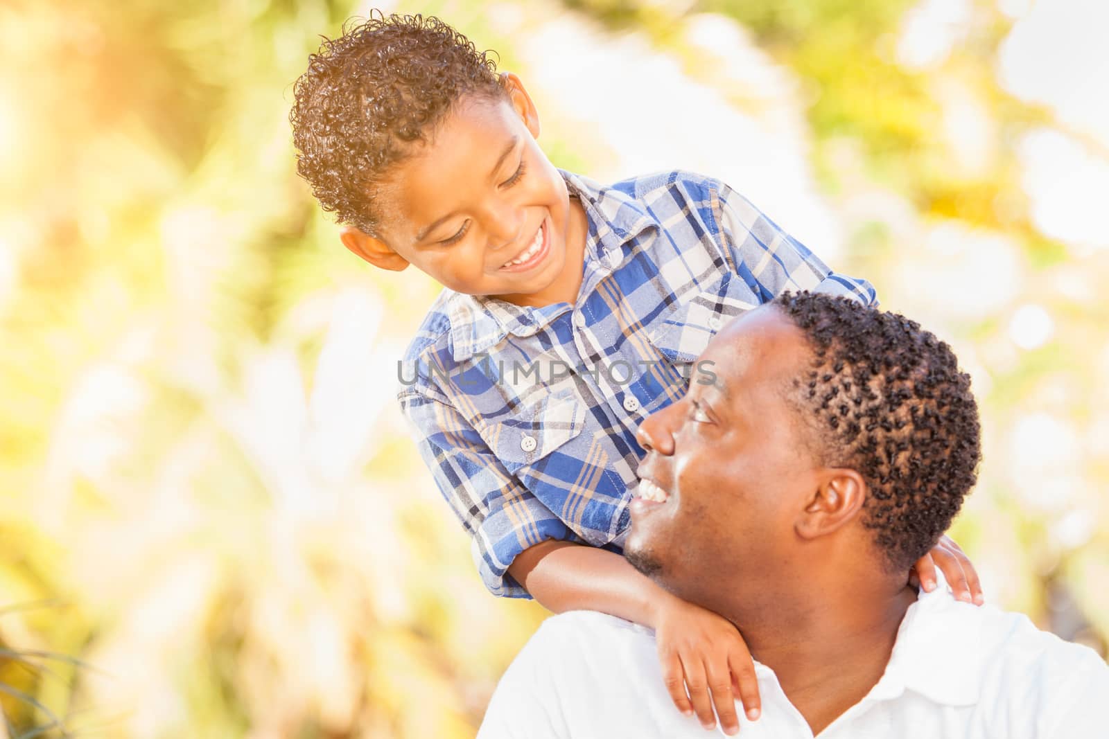 Mixed Race Son and African American Father Playing Outdoors Together.