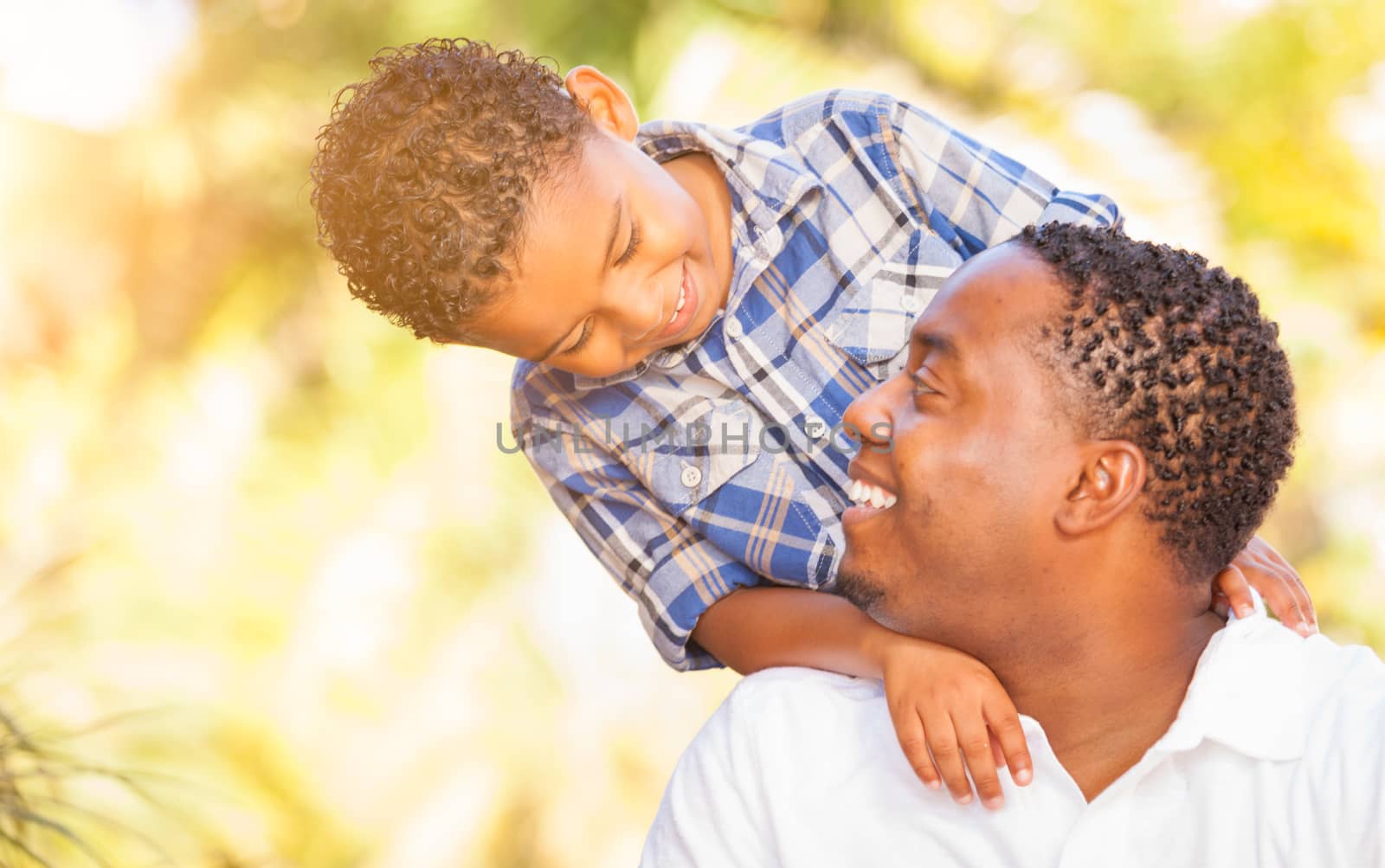 Mixed Race Son and African American Father Playing Outdoors Together.