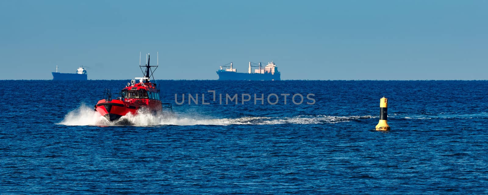 Red pilot ship moving from the Baltic sea