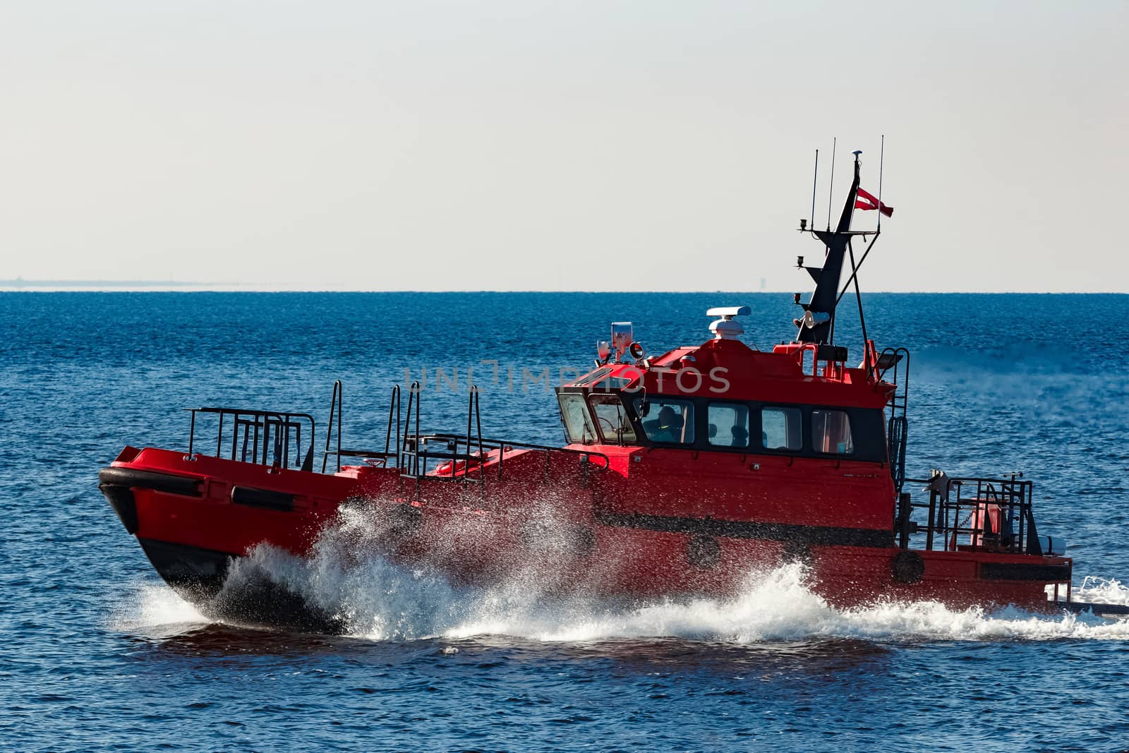 Red pilot ship moving from the Baltic sea