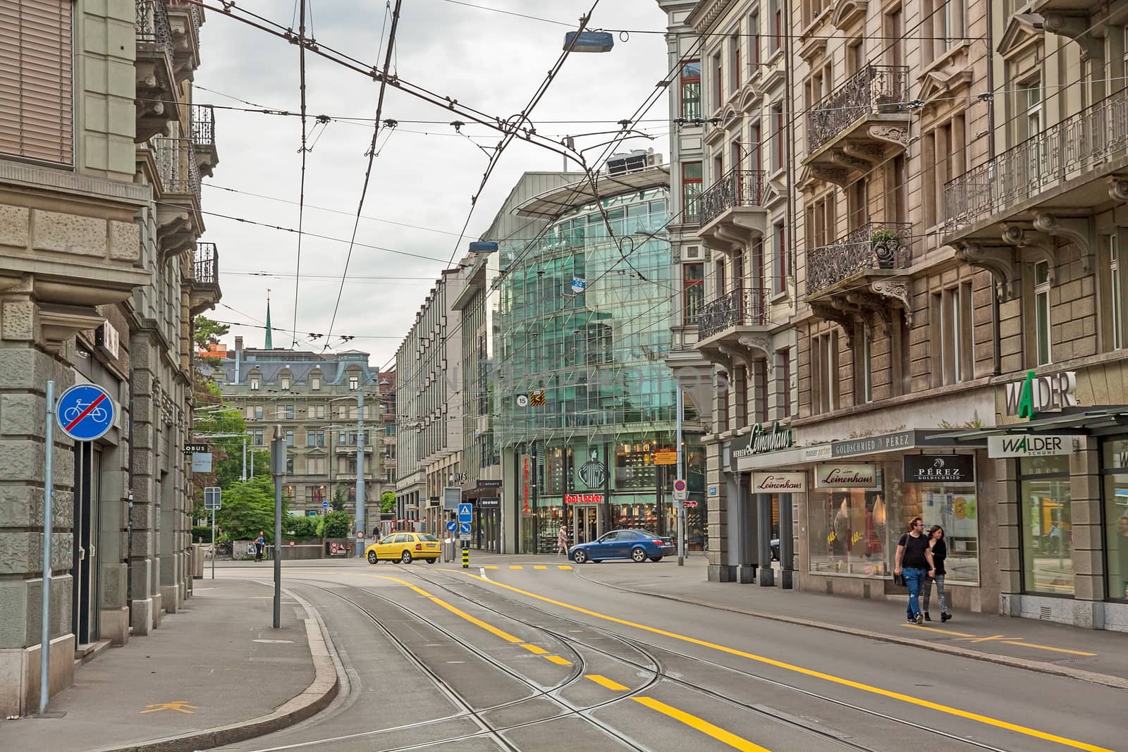 Zurich, Switzerland - June 10, 2017: Inner-city of Zurich with old and modern facade buildings. Tram rails in front.