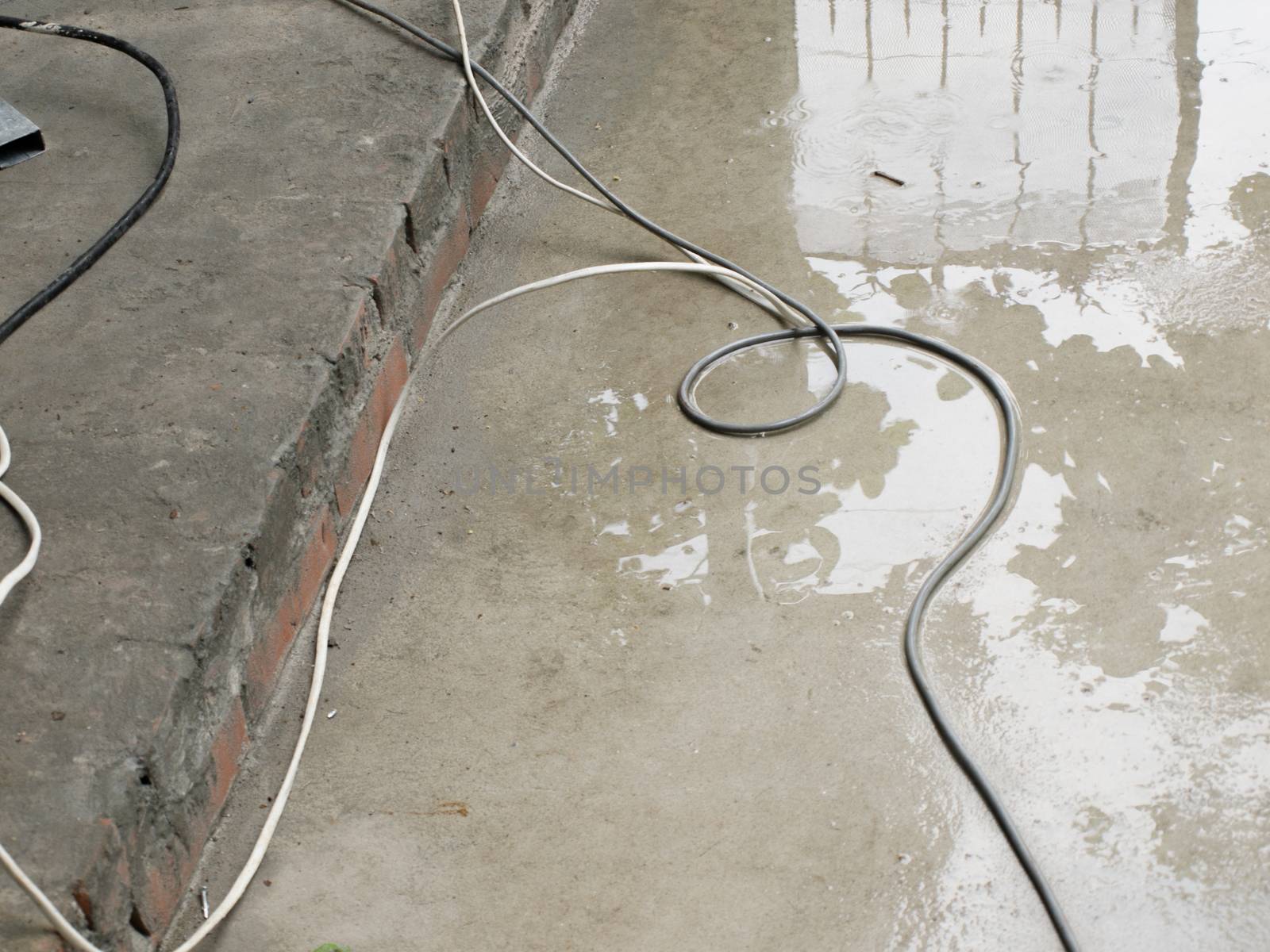 COLOR PHOTO OF WIRE ON WET CONCRETE GROUND