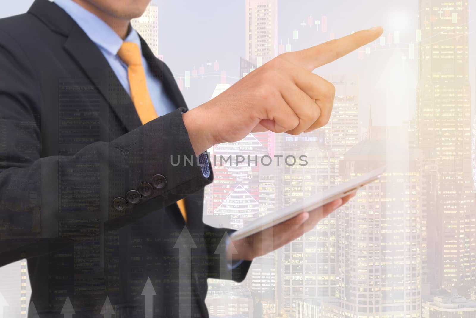 business man Trading concept using the tablet with financial graph on cityscape background, Double exposure style.