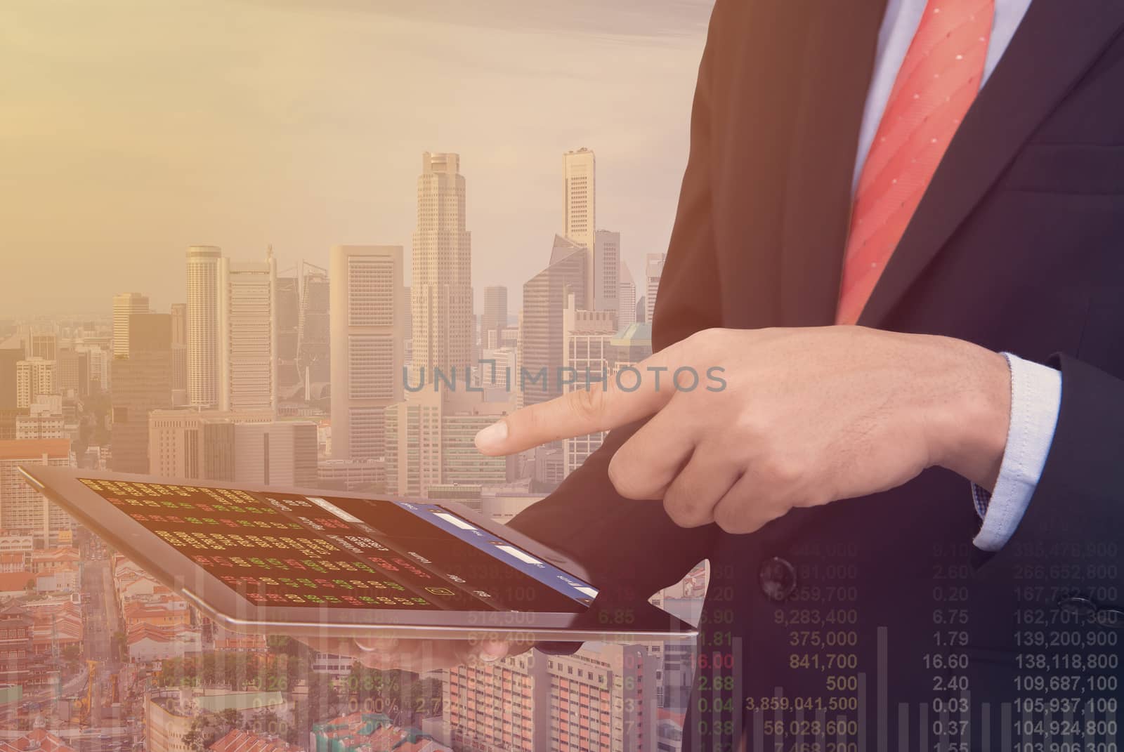 business man Trading concept using the tablet with financial graph on cityscape background, Double exposure style.