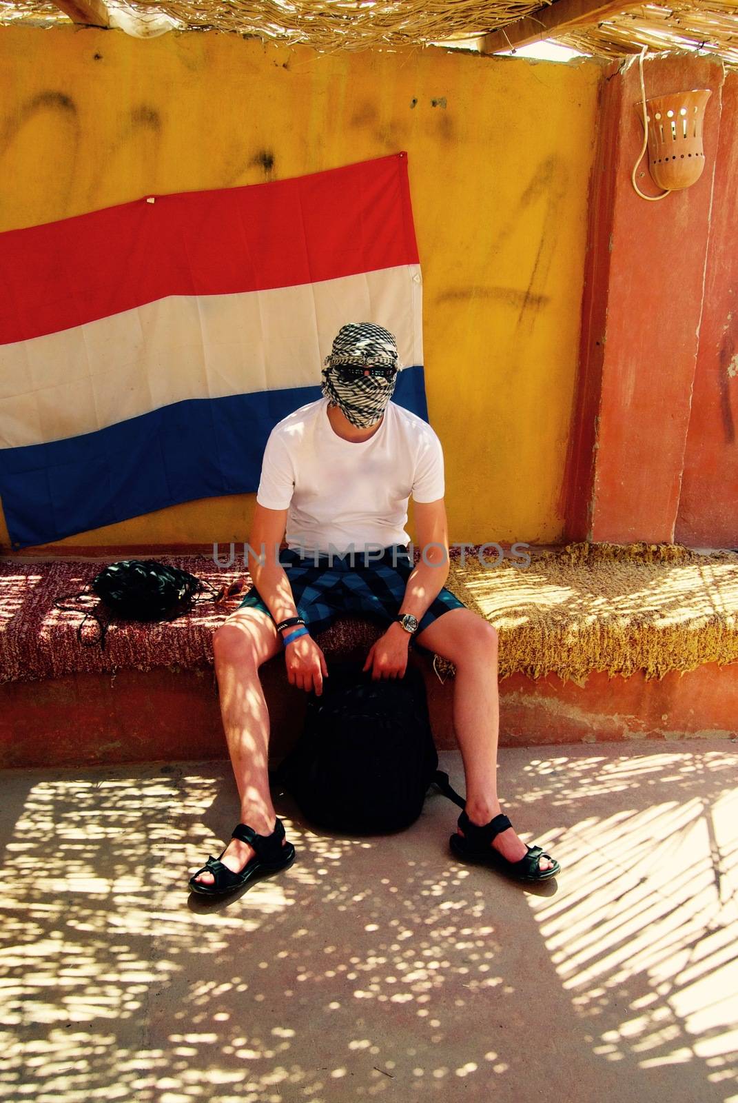 White young man on the safari in Egypt near flag. Africa travel.