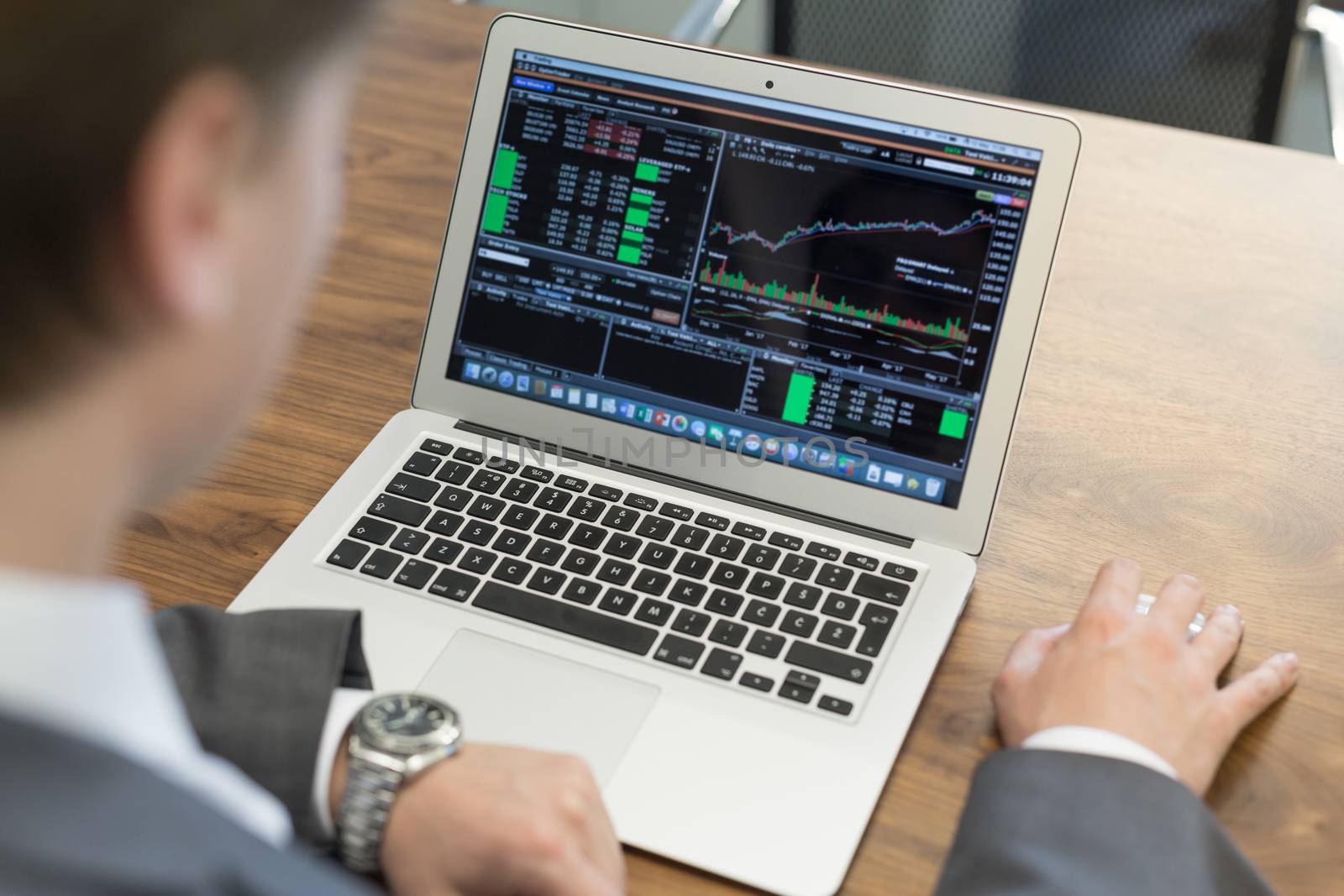 Corporate businessman analyzing economic data on laptop computer. Man's hands on notebook computer, business person at workplace.