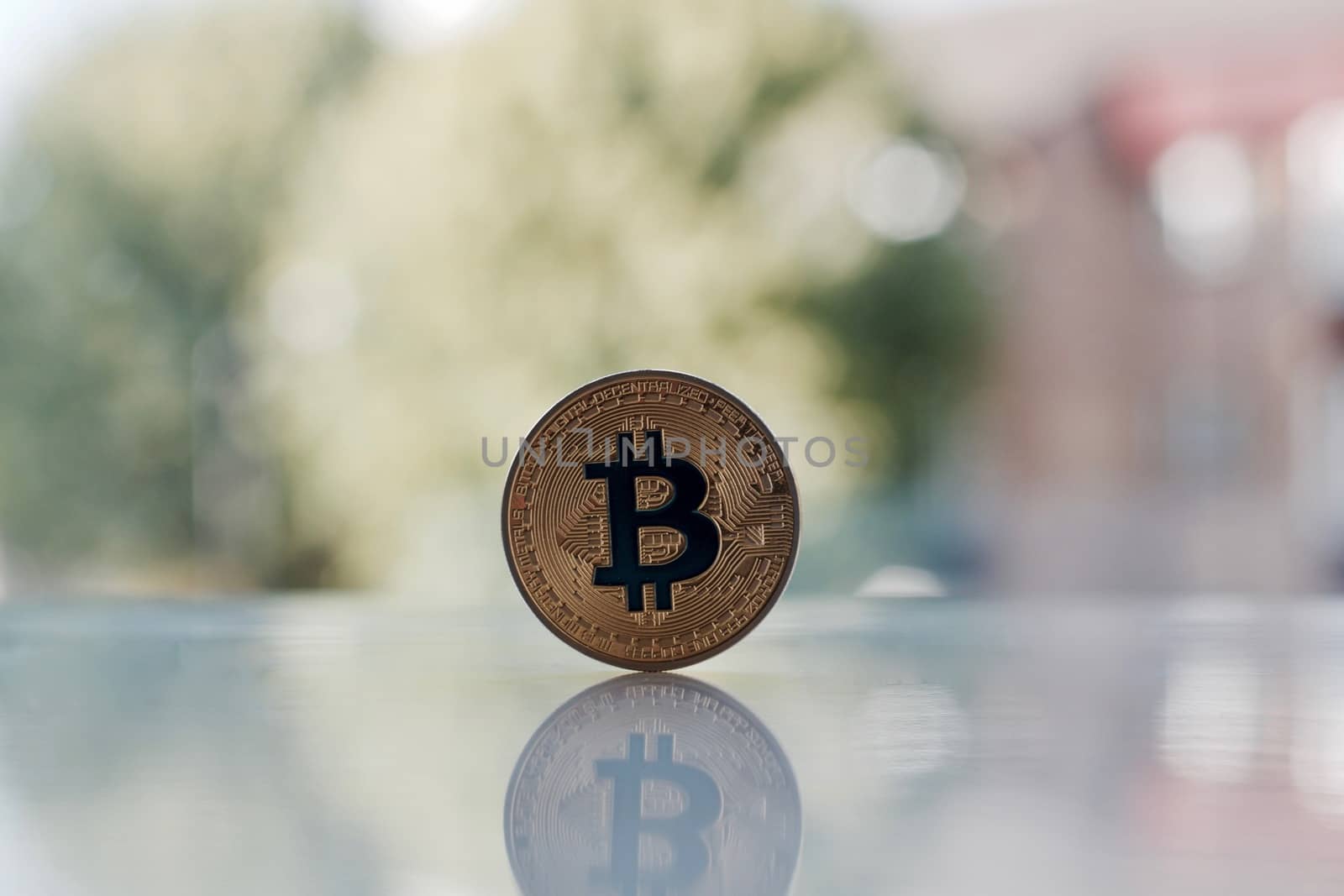 Digital currency physical gold bitcoin coin on the table near window