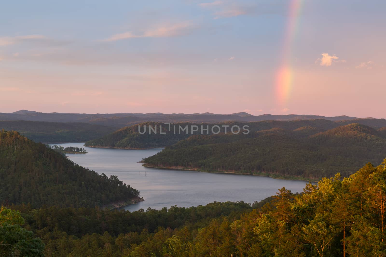 A rainbow in the sky during a beautiful sunset at Broken Bow Lake, Oklahoma.