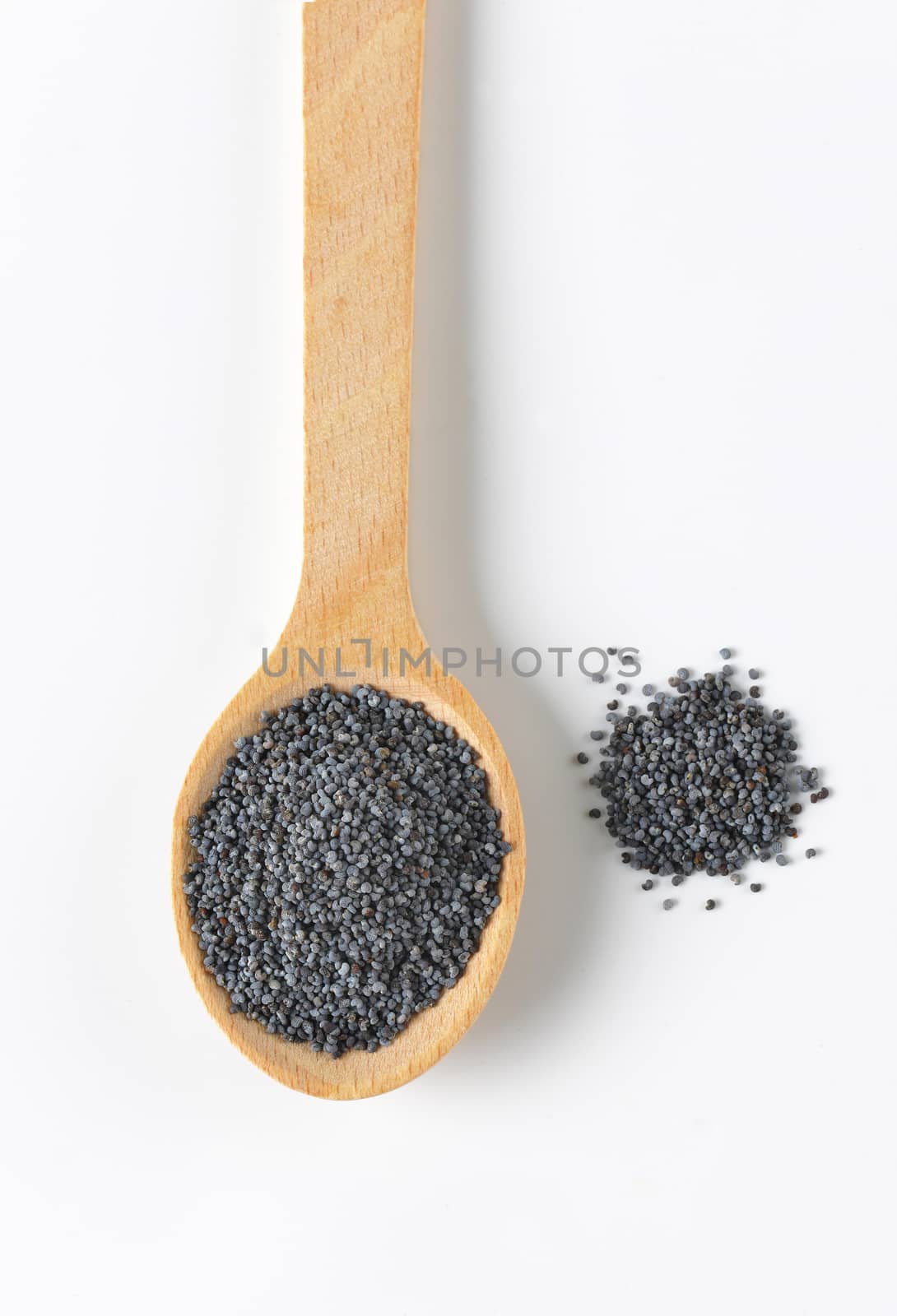 whole ripe poppy seeds on small wooden spoon