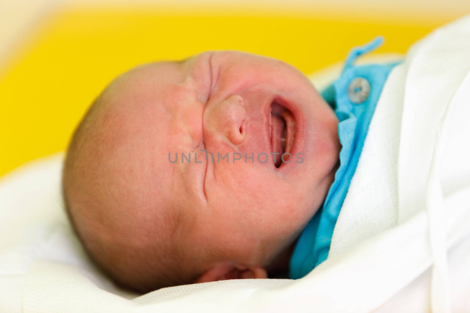 crying newborn baby infant in the hospital, the first hours of the new life, one days after birth
