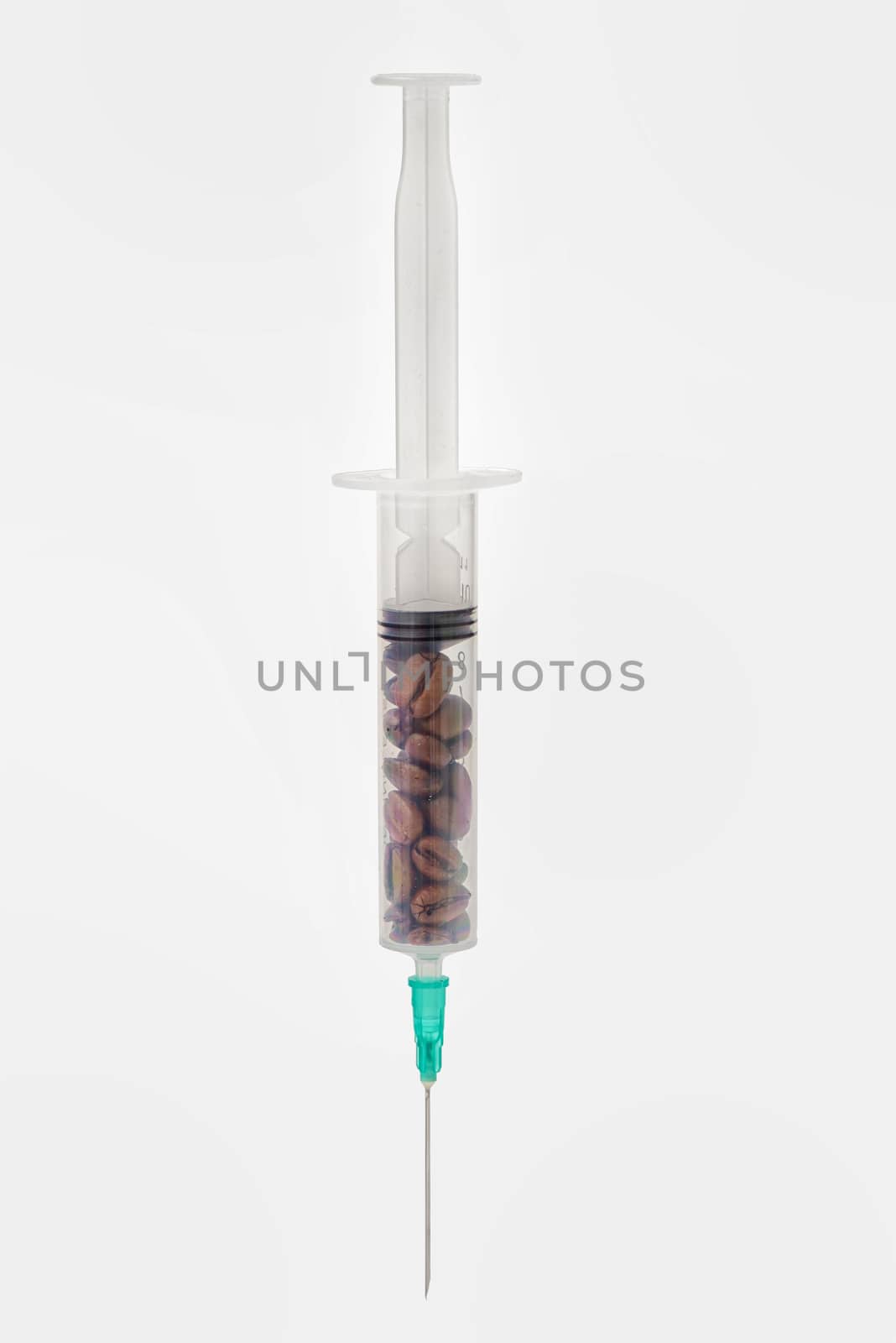 Coffee beans in syringe on white background