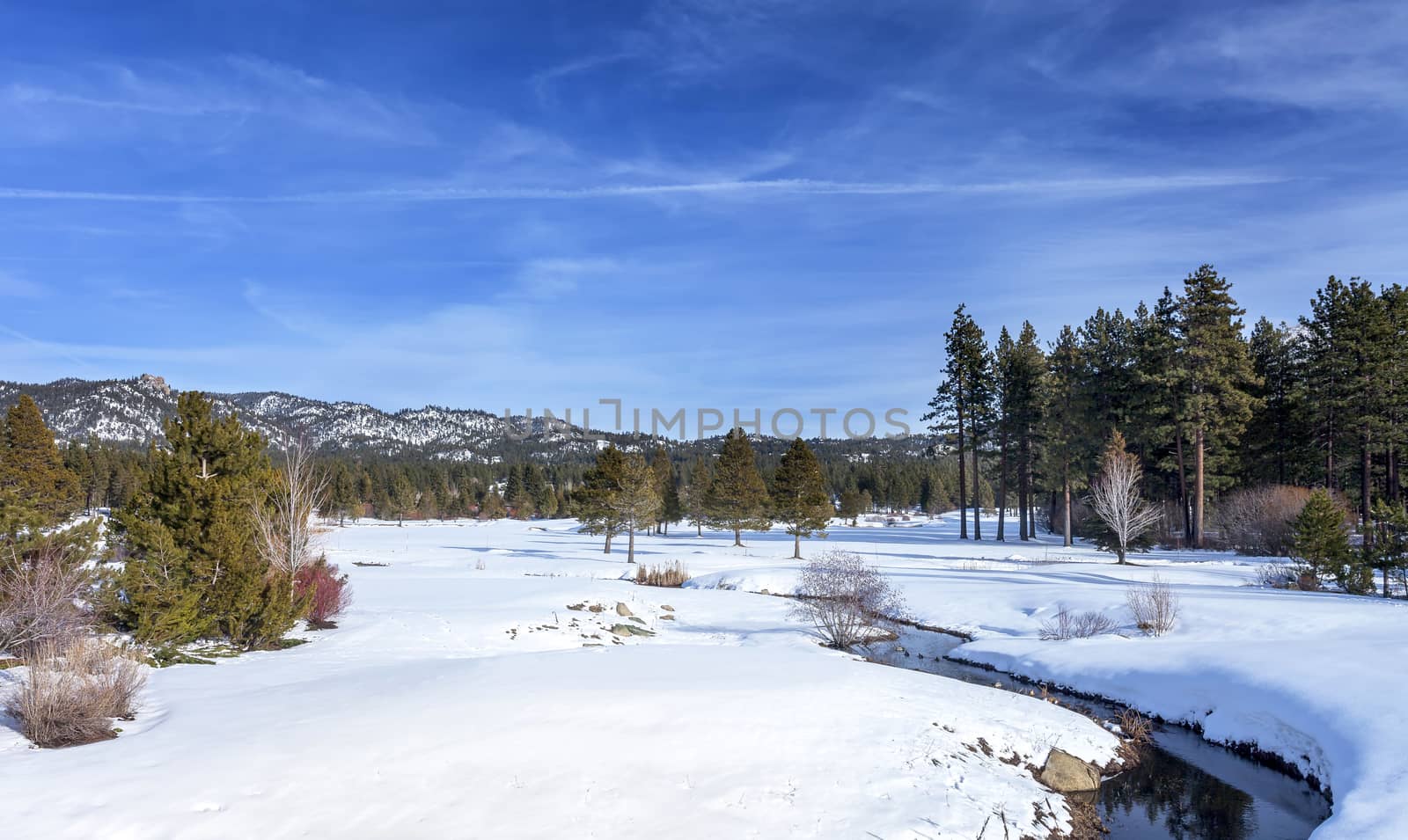 A winter scene overlooking a meadow and creek in Lake Tahoe, California. This image is looking East towards Nevada.