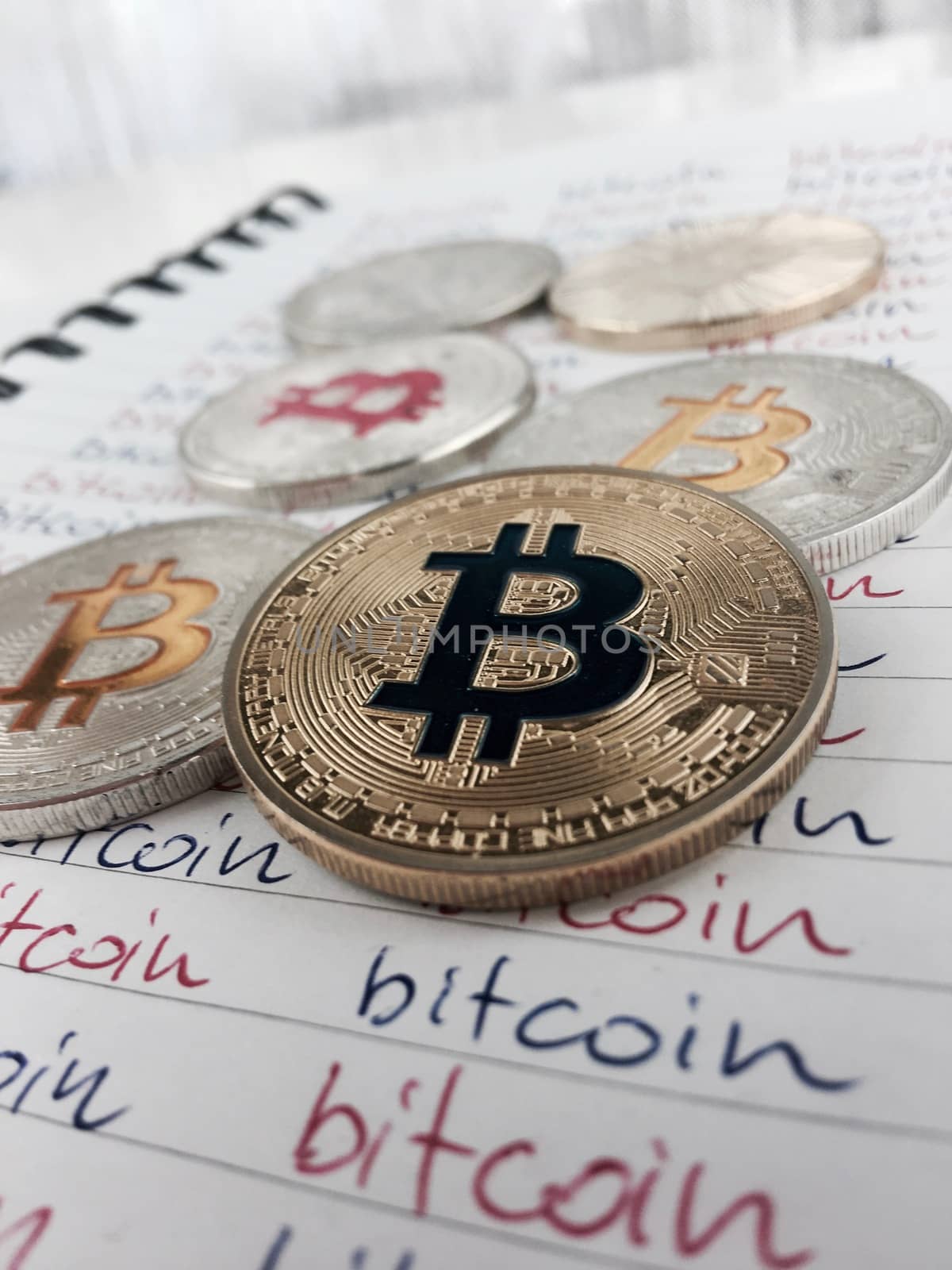 Cryptocurrency physical gold and silver bitcoin coins in notebook.