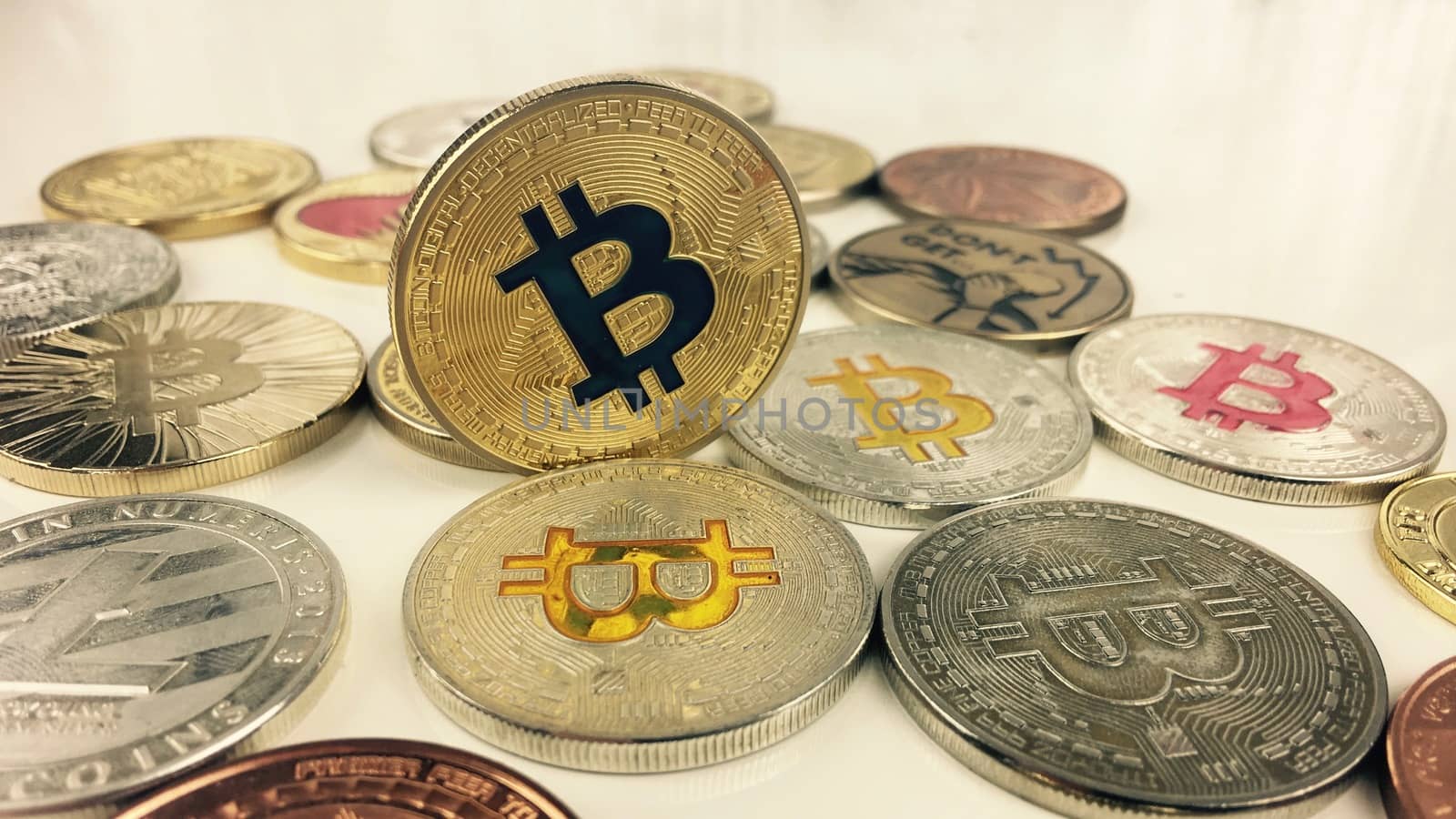 Cryptocurrency physical gold bitcoin coin near silver and brass bitcoins.