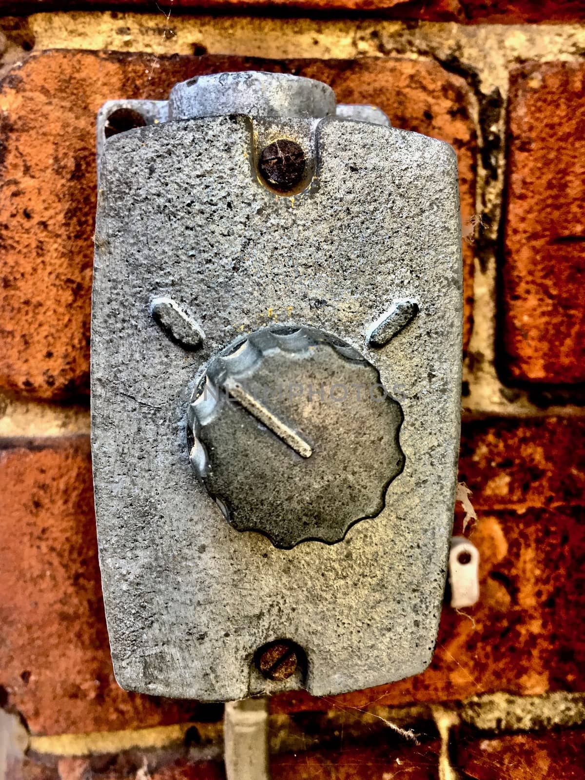 Very old metal switch on the brick old wall in england.