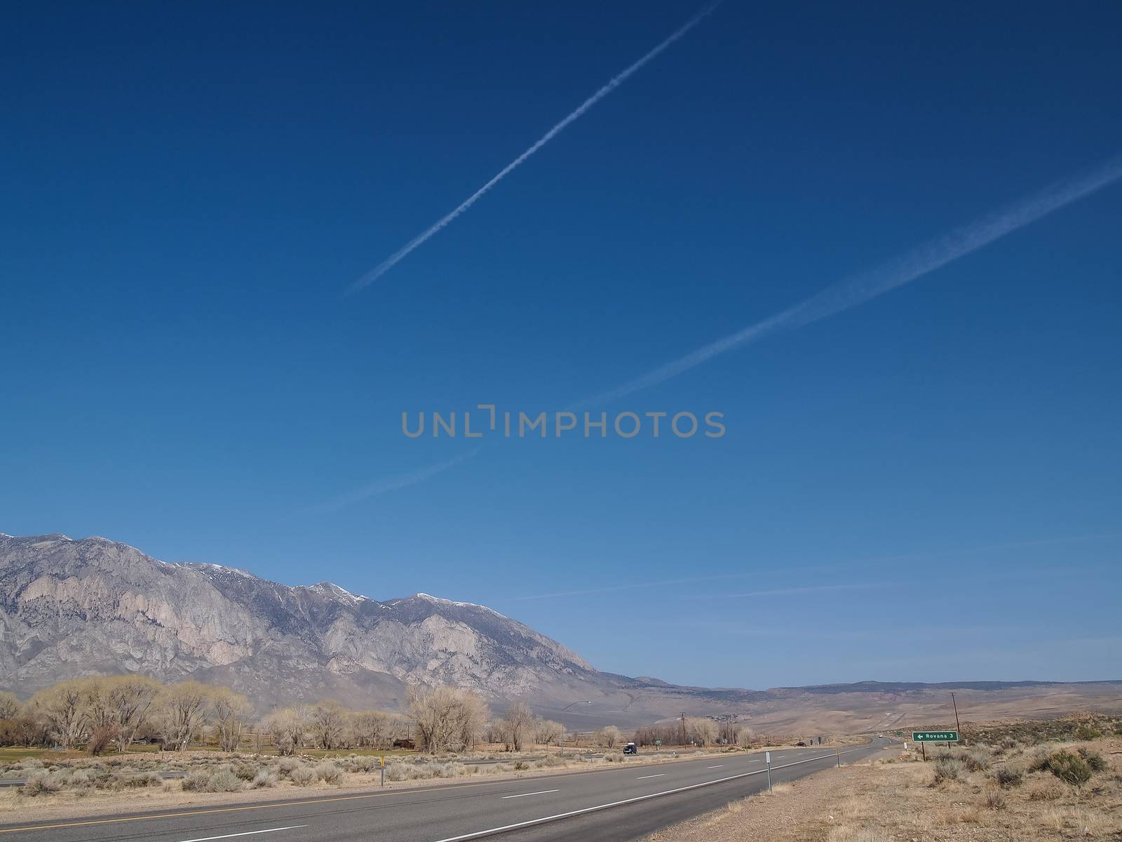 Driving through the snow capped mountains, blue sky, Desert landscape in California , USA