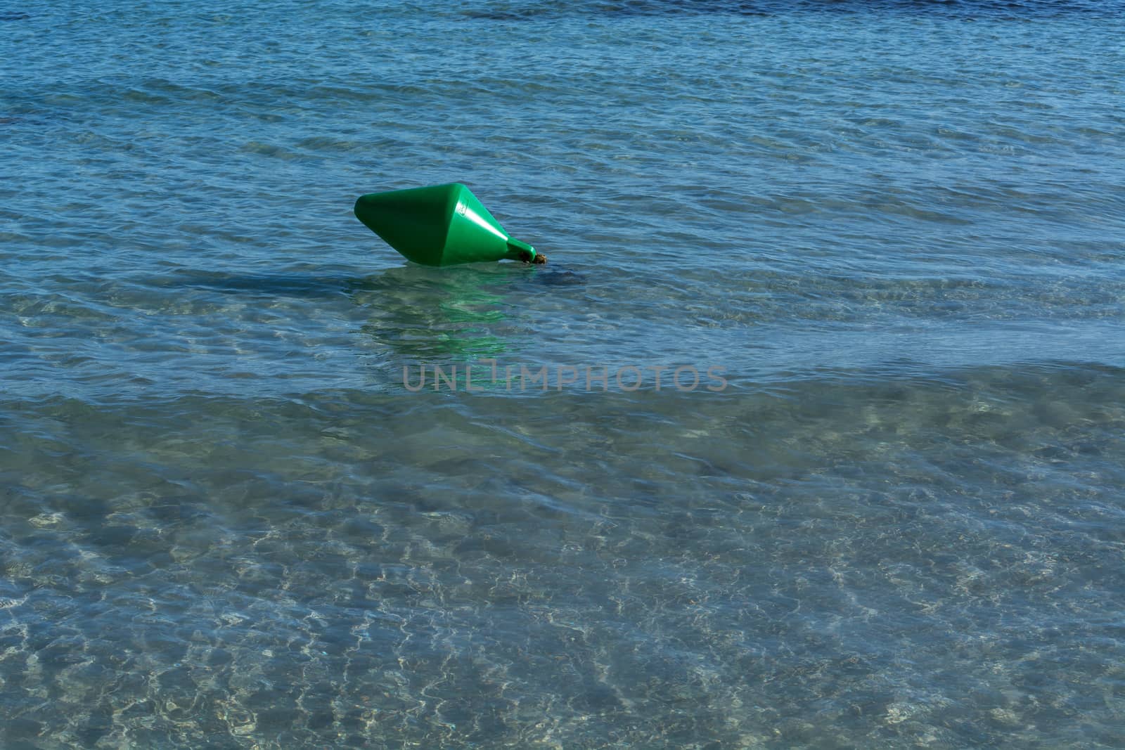 Green buoy as a shipping sign or sea sign in the sea.