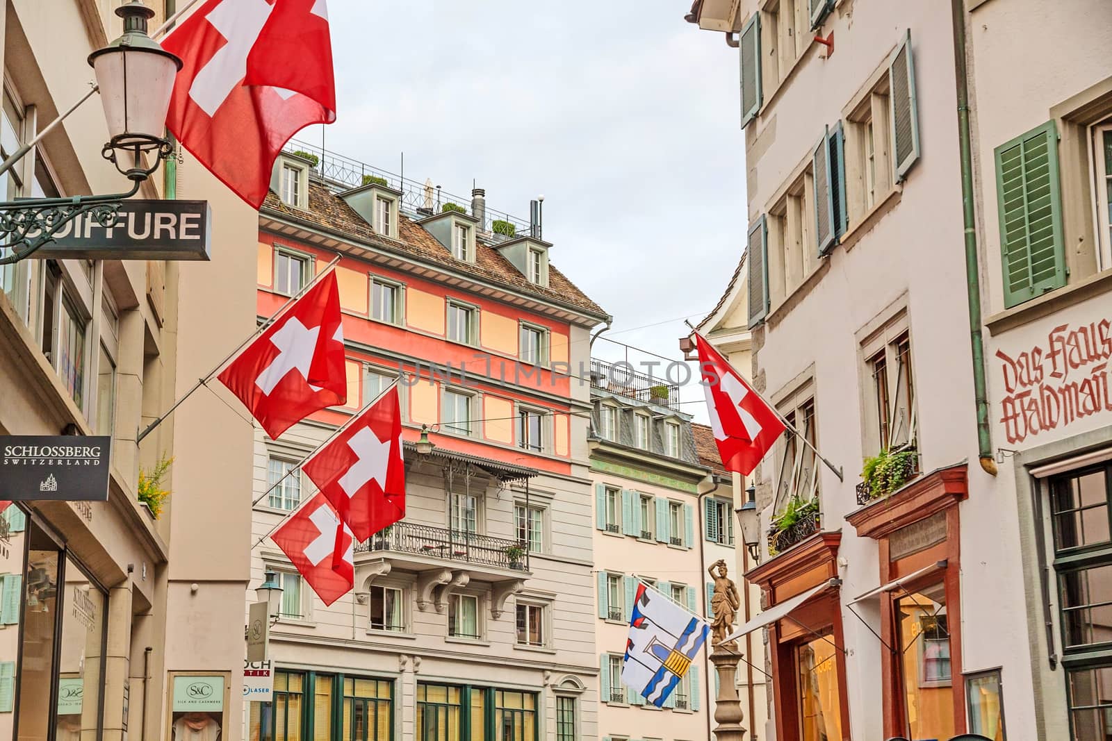 Zurich (downtown), old street with swiss flags by aldorado